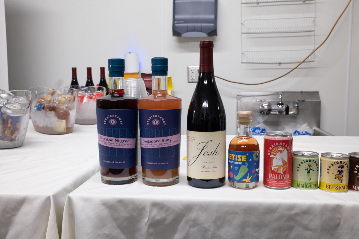 Bottles of Straightaway cocktails, a bottle of Josh wine and small cans on a white tablecloth.