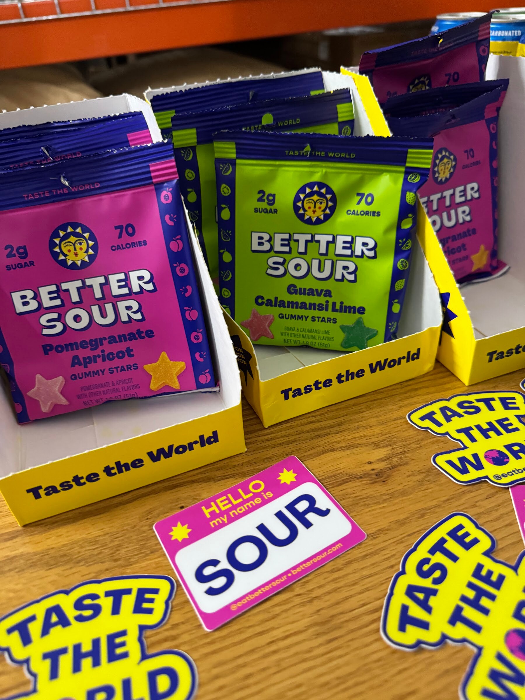 Boxes of Better Sour pomegranate apricot and guava calamansi lime candy with stickers.