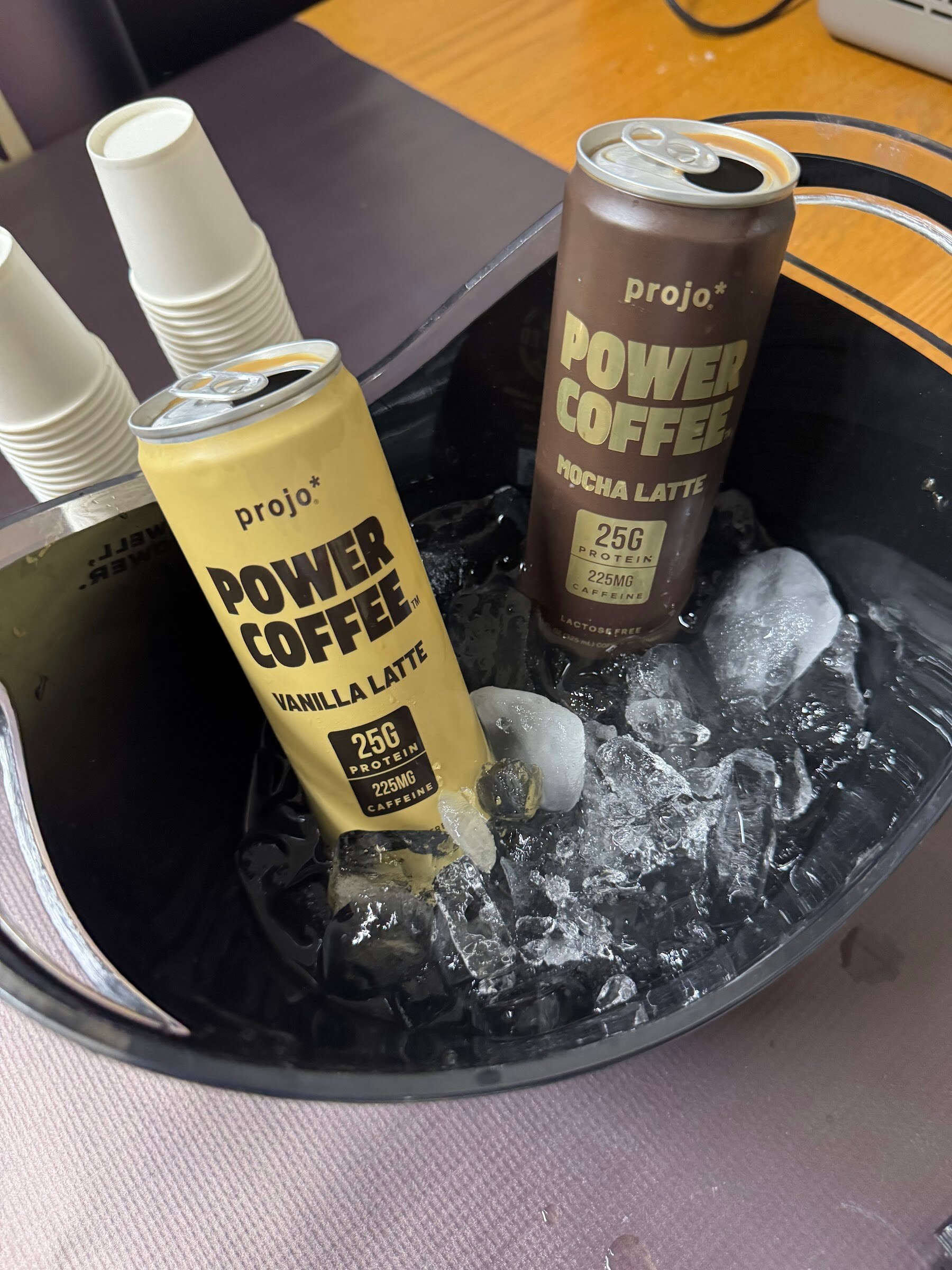 Cans of Projo Power Coffee chilling in an ice bucket.