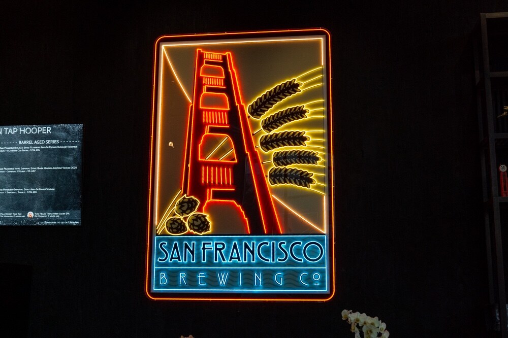 Neon sign of the Golden Gate Bridge with wheat stalks above the words San Francisco Brewing Co.