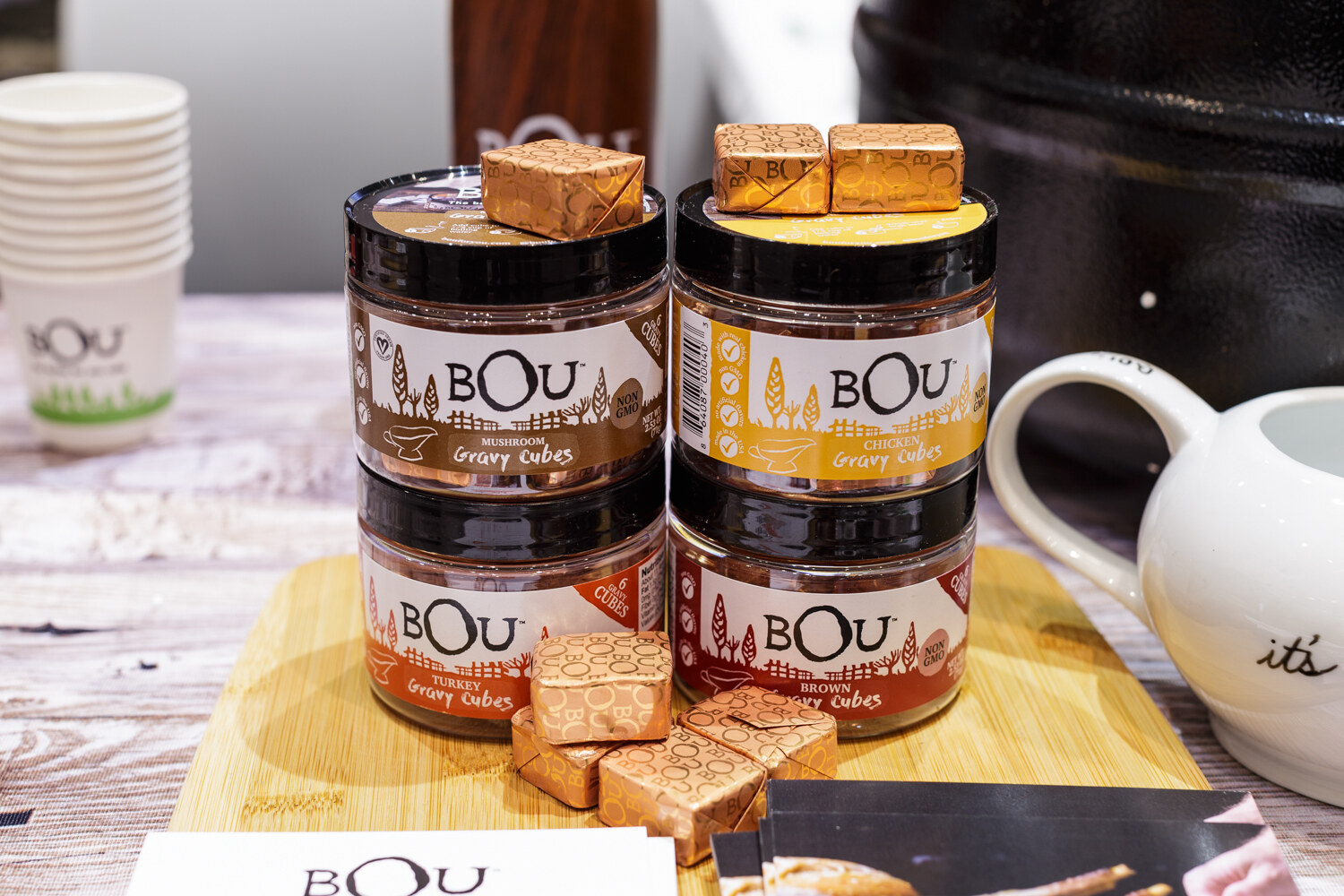 Jars of Bou bouillon cubes with wrapped cubes on a wooden board.