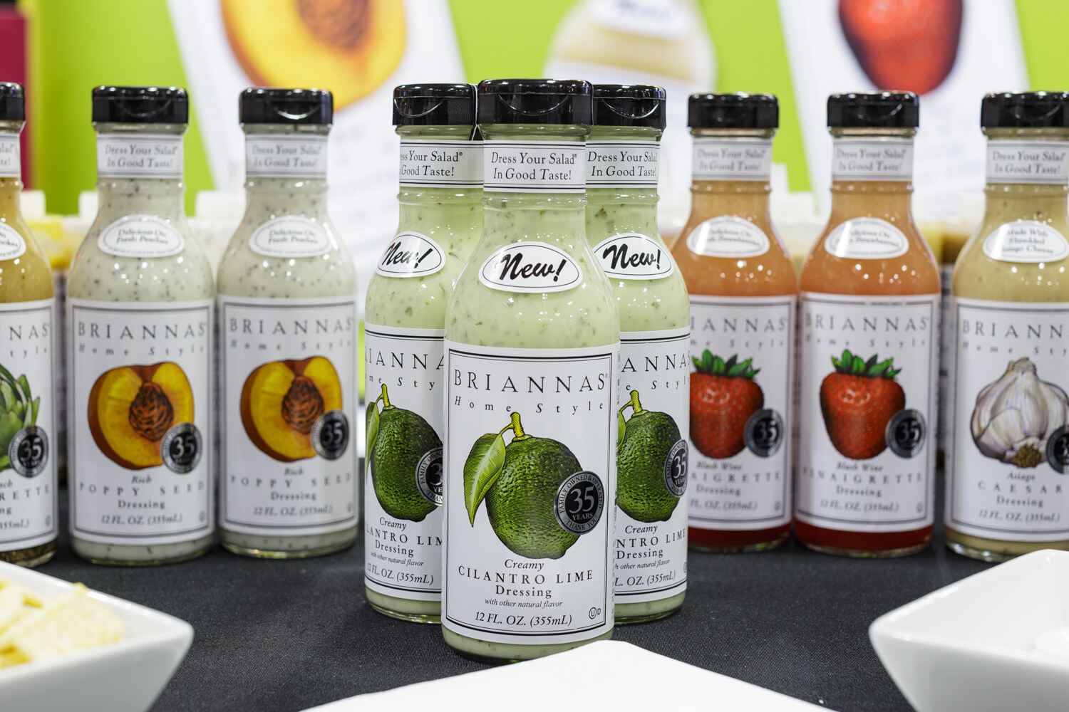 Bottles of salad dressing in a row on a shelf.