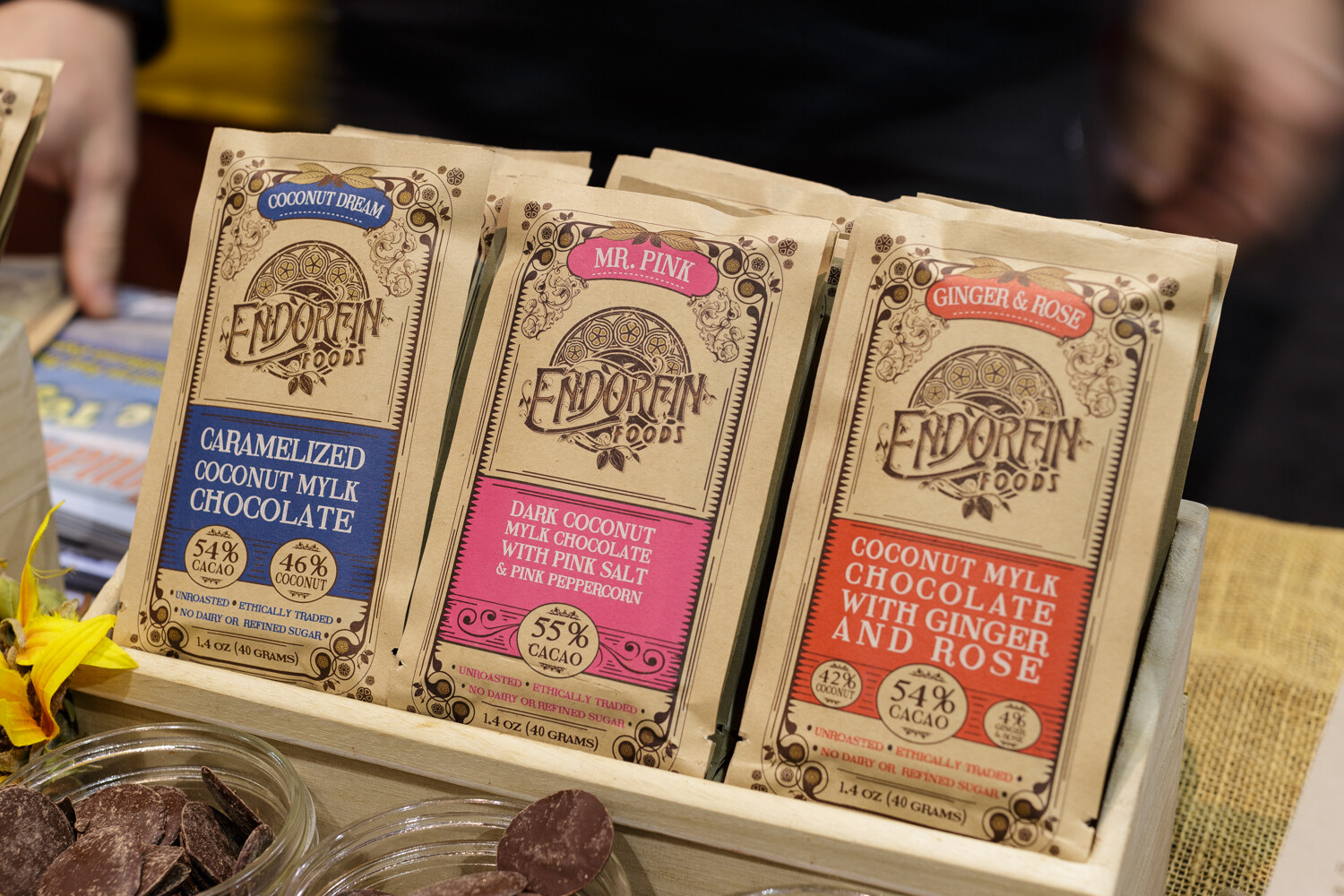 Rows of paper-wrapped chocolate bars in a wooden box.