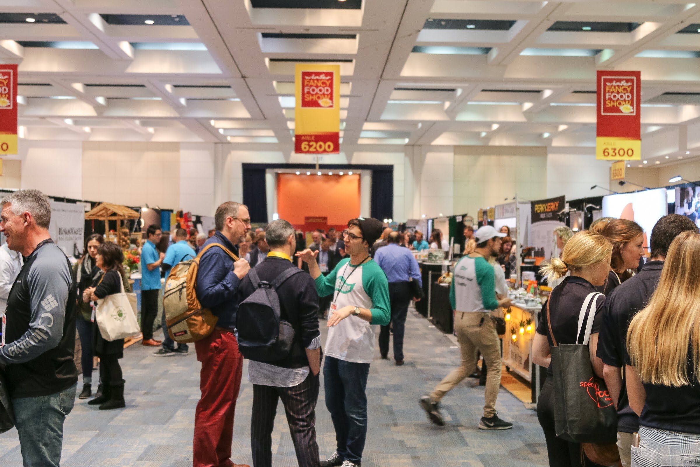 Crowded aisle with booths on either side.
