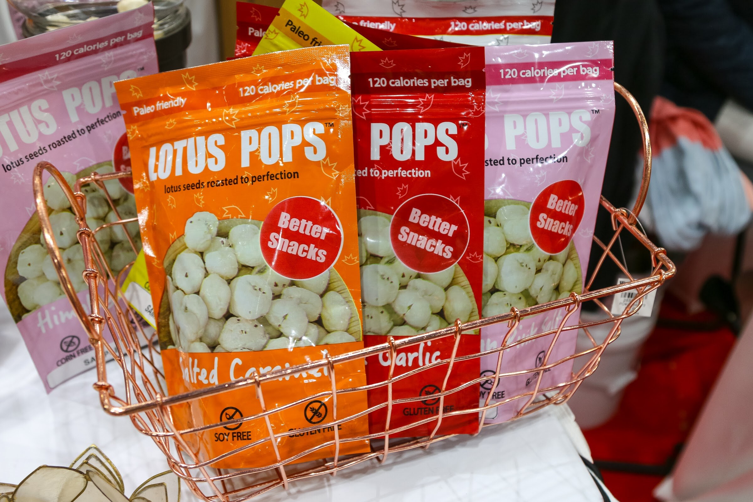 Bags of Lotus Pops in spicy, garlic and other flavors in a wire basket.