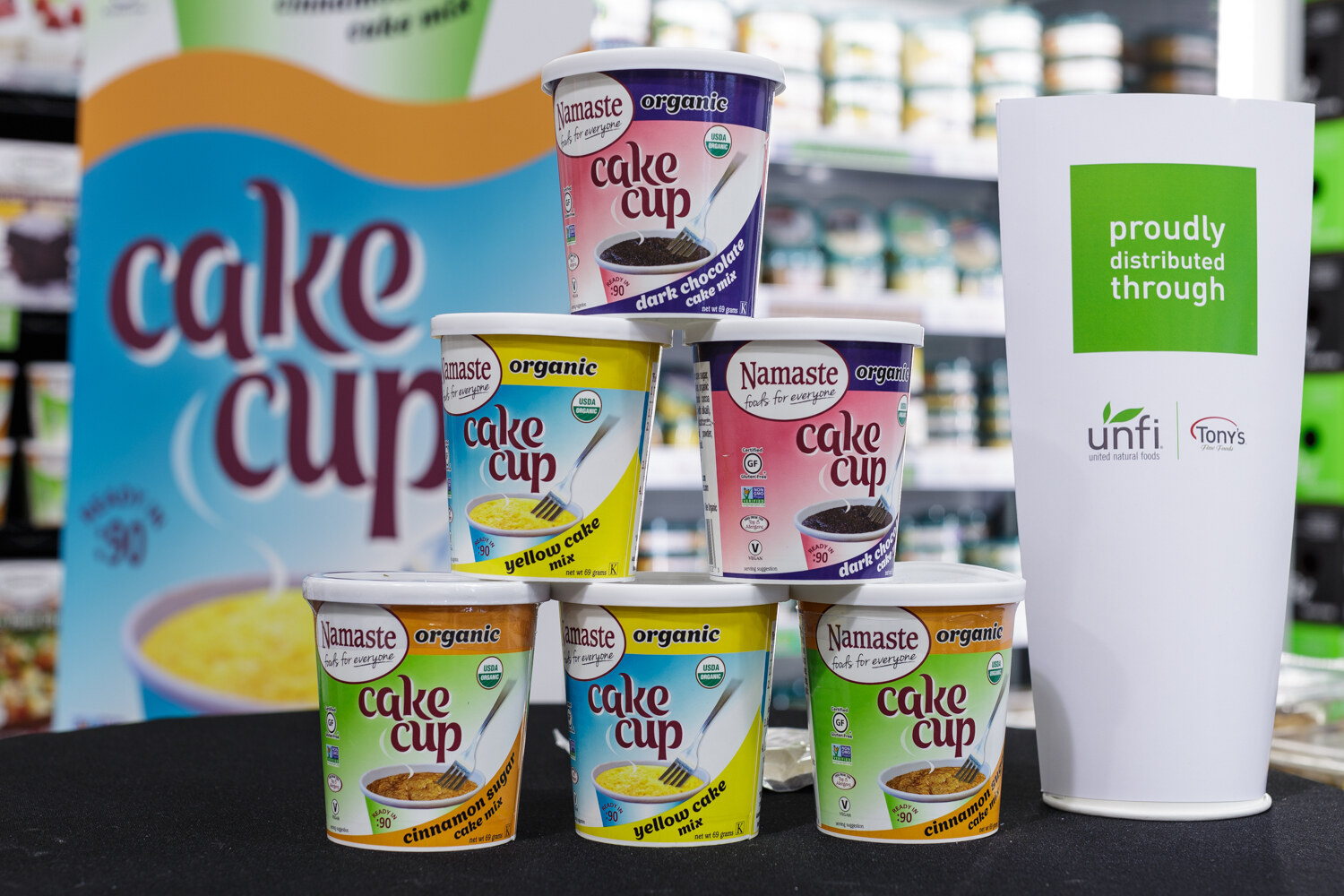 Stacked cake cup containers beside a white cup.
