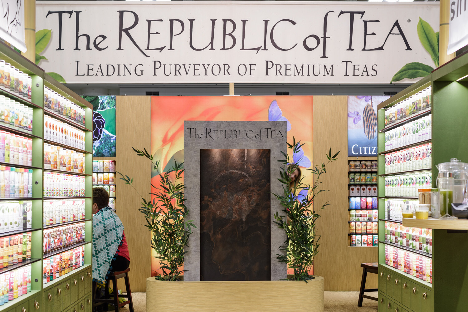 Shelves of tea tins and boxes at a tea company booth.