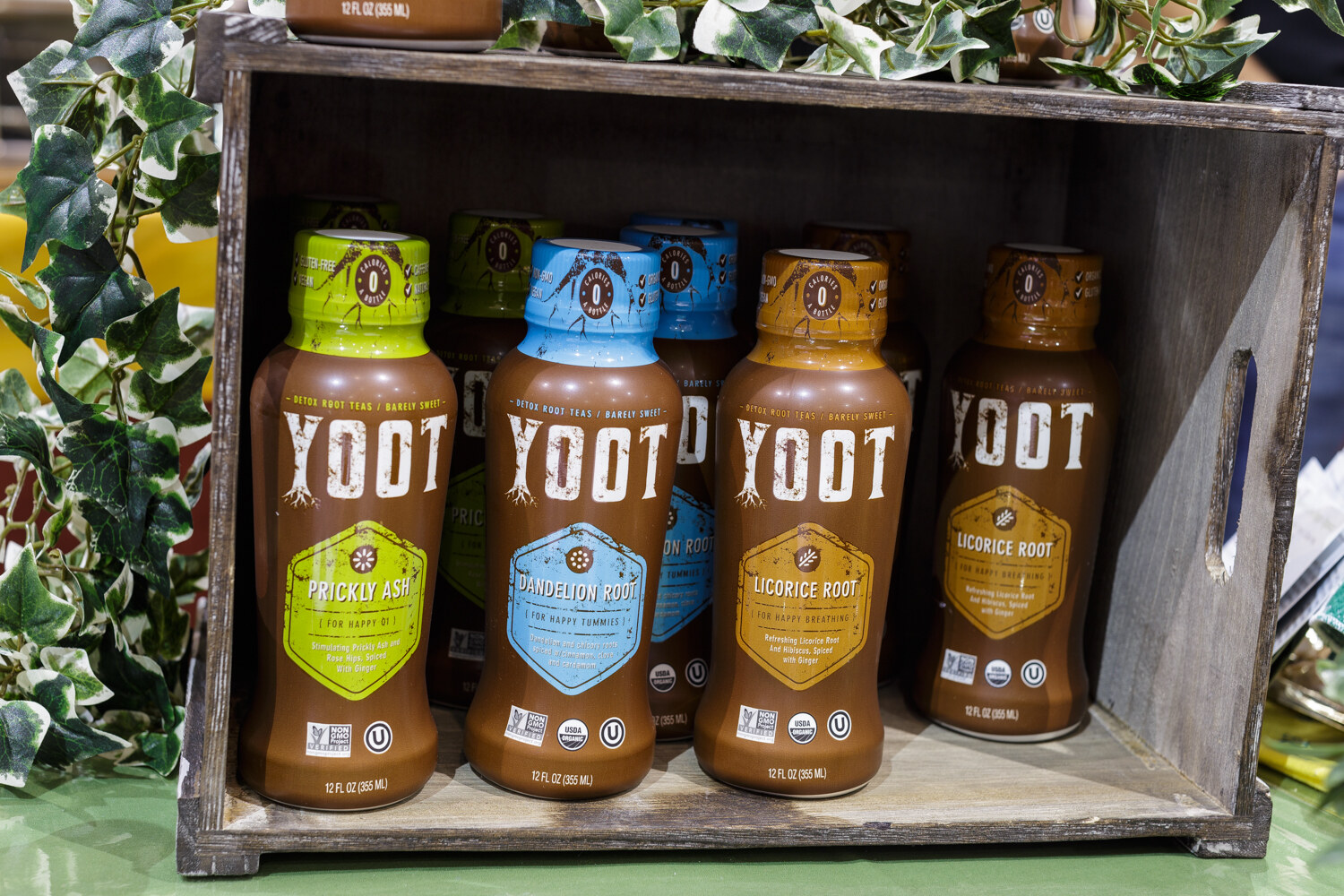 Four bottles of root tea in a crate.