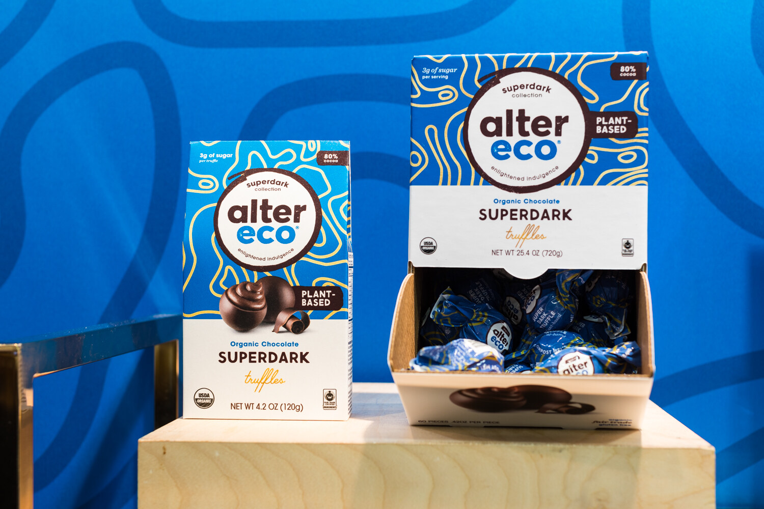 Photo of Alter Eco superdark truffle boxes on a blue background.