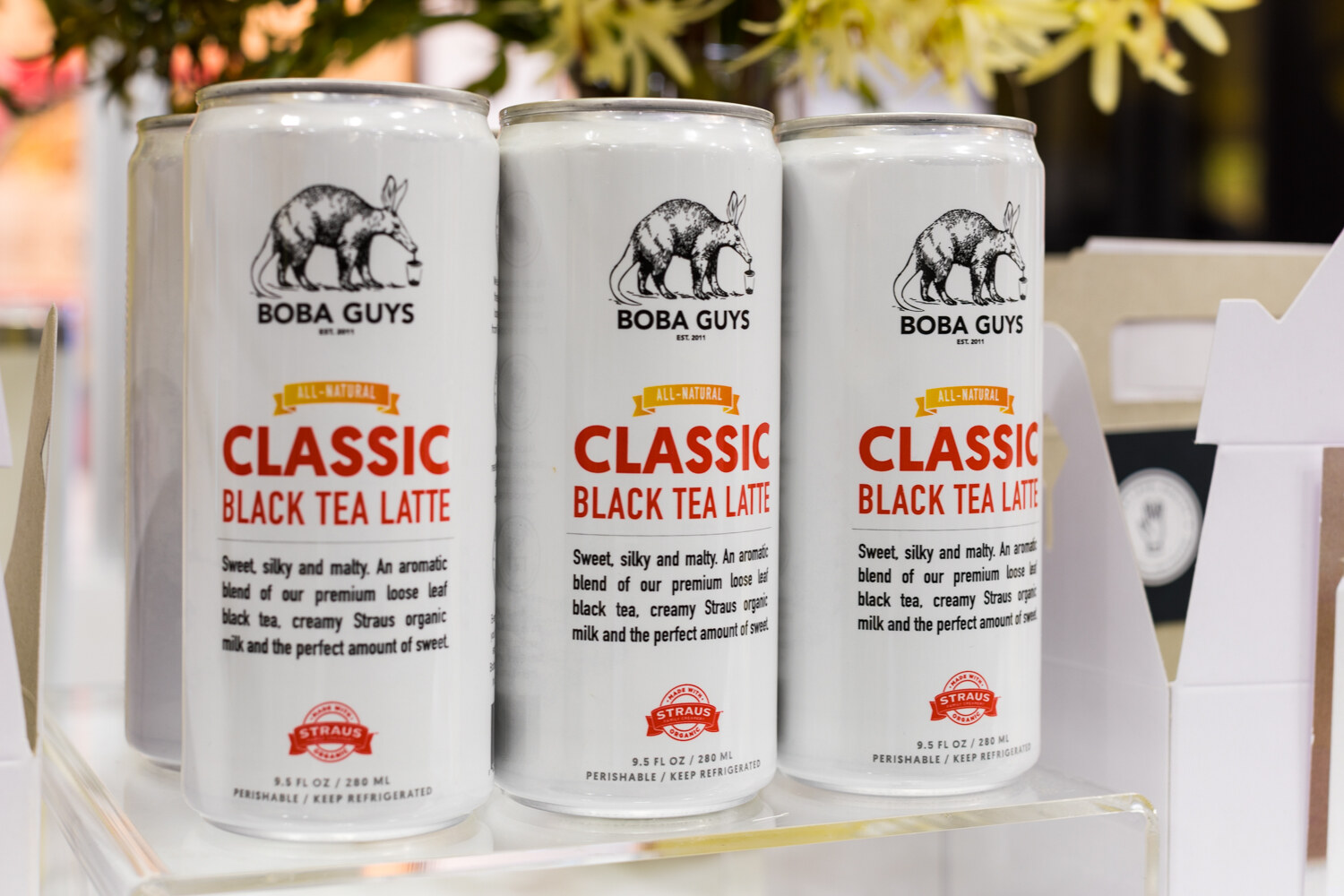 Photo of three white cans of Boba Guys classic black tea latte.