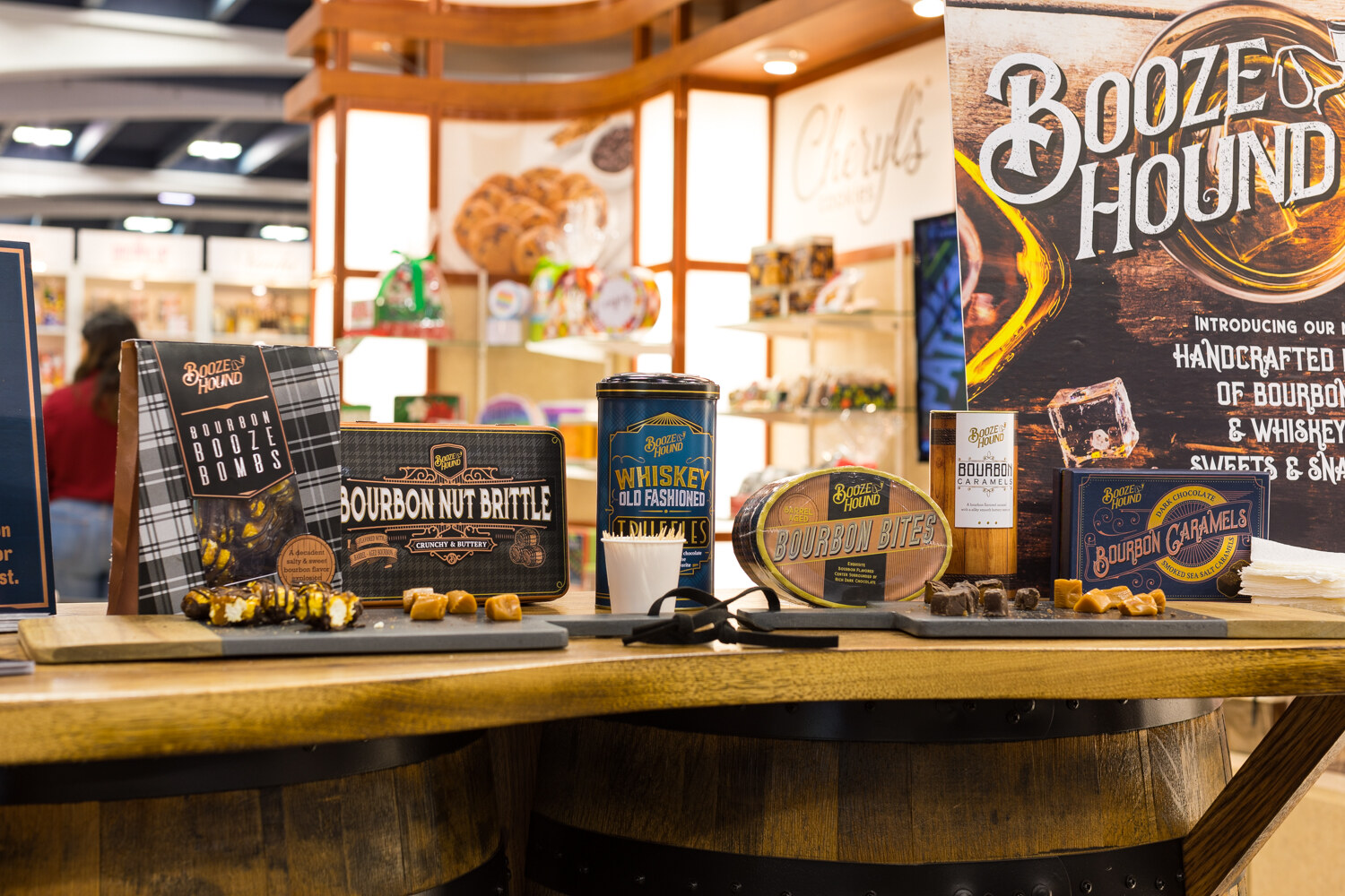 Photo of a Booze Hound display of bourbon and whiskey sweets and snacks on barrels.