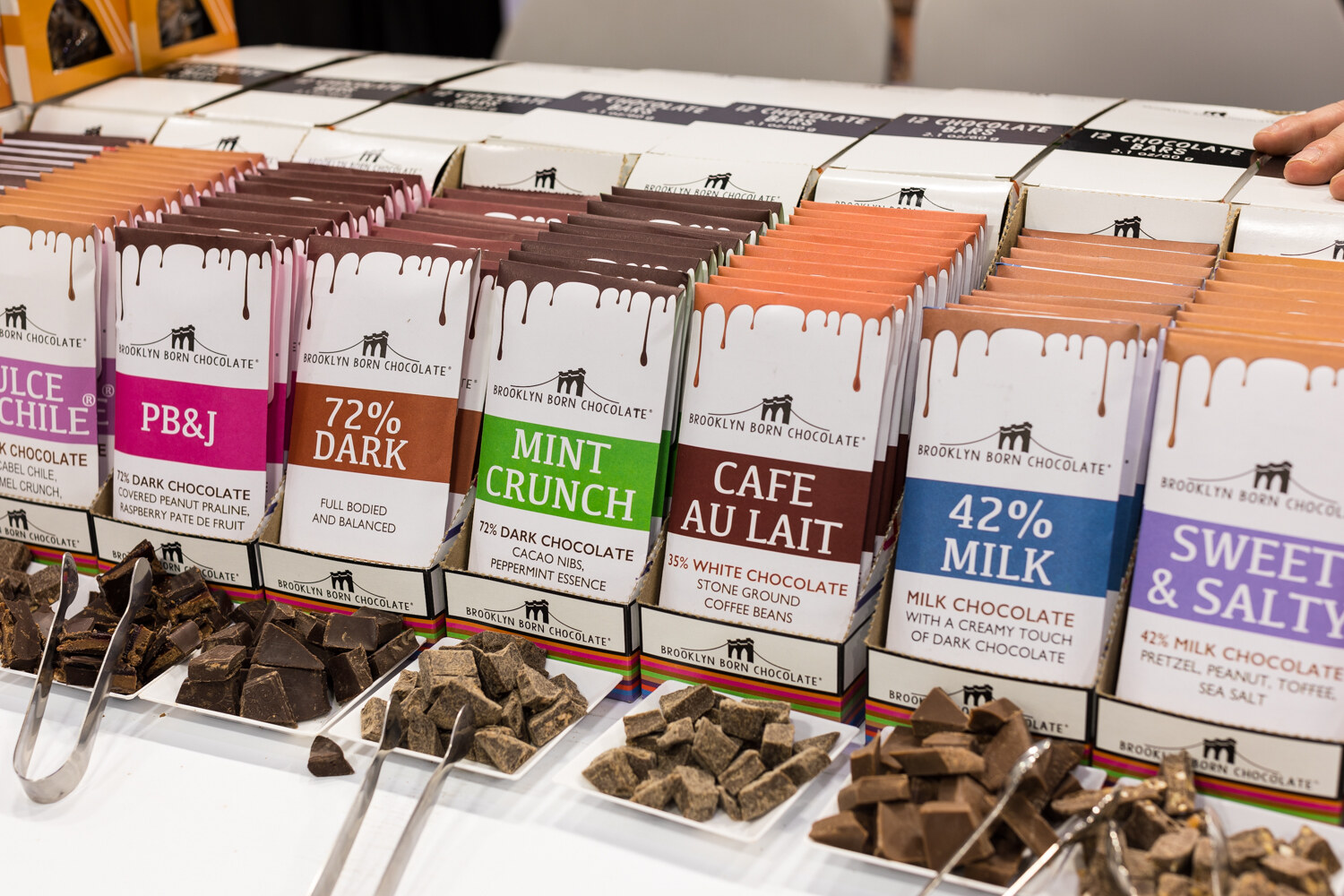 Photo of chocolate bars in flavors including PB&J and mint crunch with sample pieces in front.
