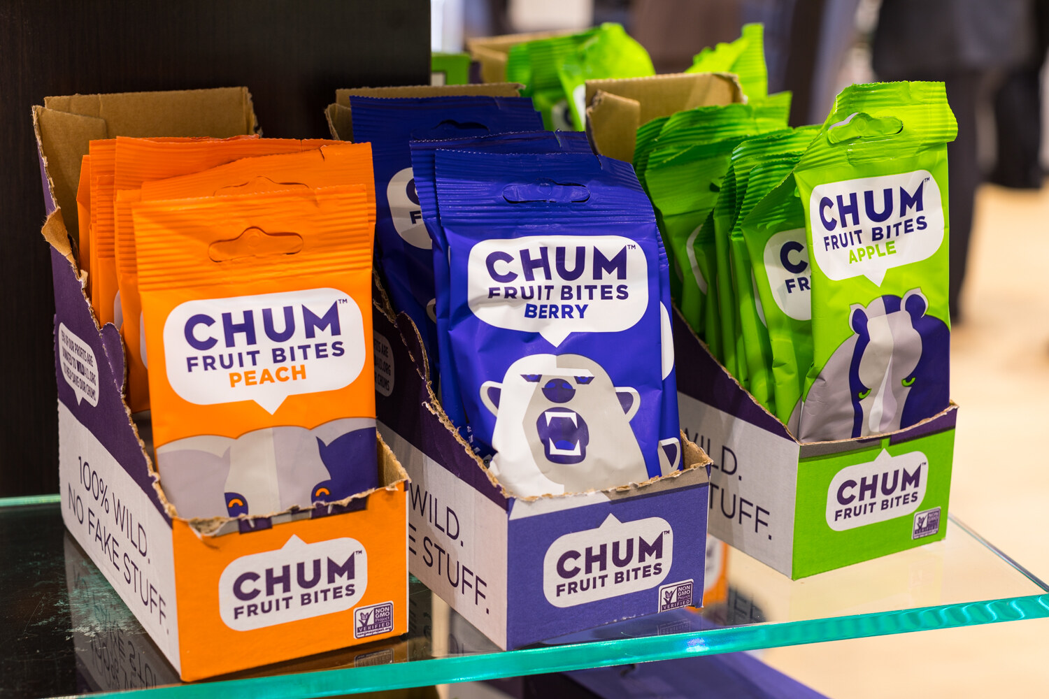 Photo of display boxes of Chum fruit bites in peach and berry on a glass shelf.