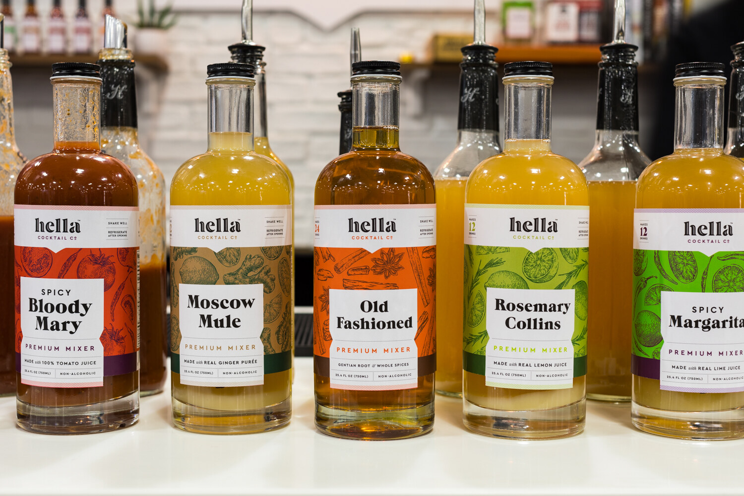 Photo of bottles of hella cocktail mixers in bloody mary, moscow mule and old fashioned.
