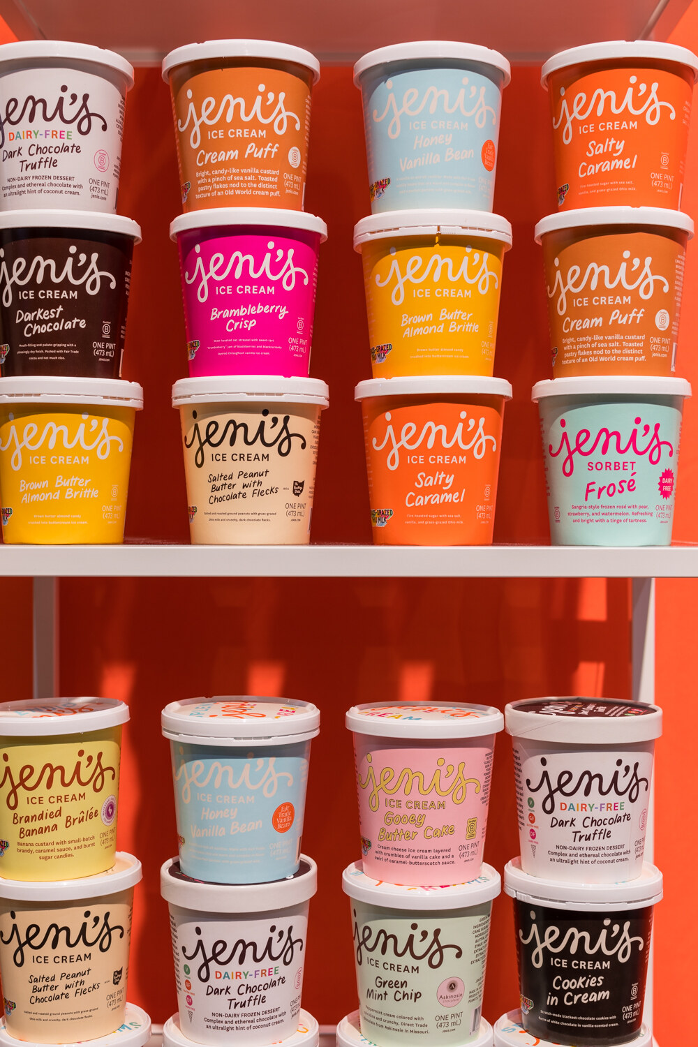 Photo of shelves of Jeni's ice cream pints in bright flavors.