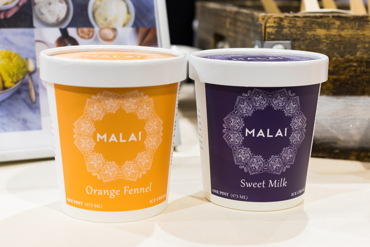 Photo of two pints of Malai ice cream in orange fennel and sweet milk.