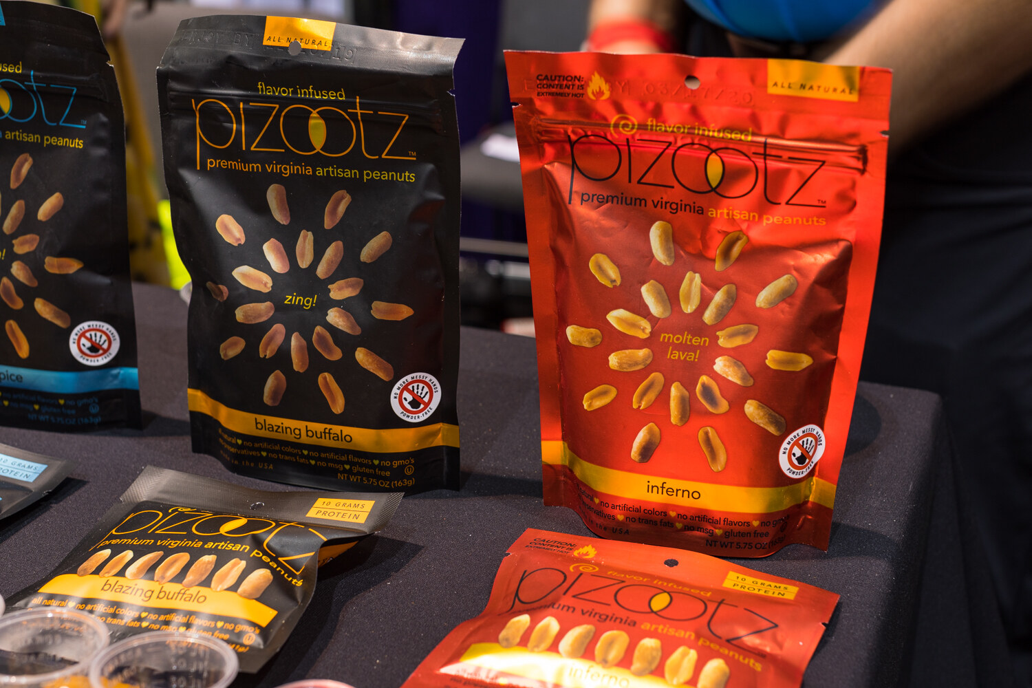 Photo of bags of Pizootz flavored peanuts on a dark table.