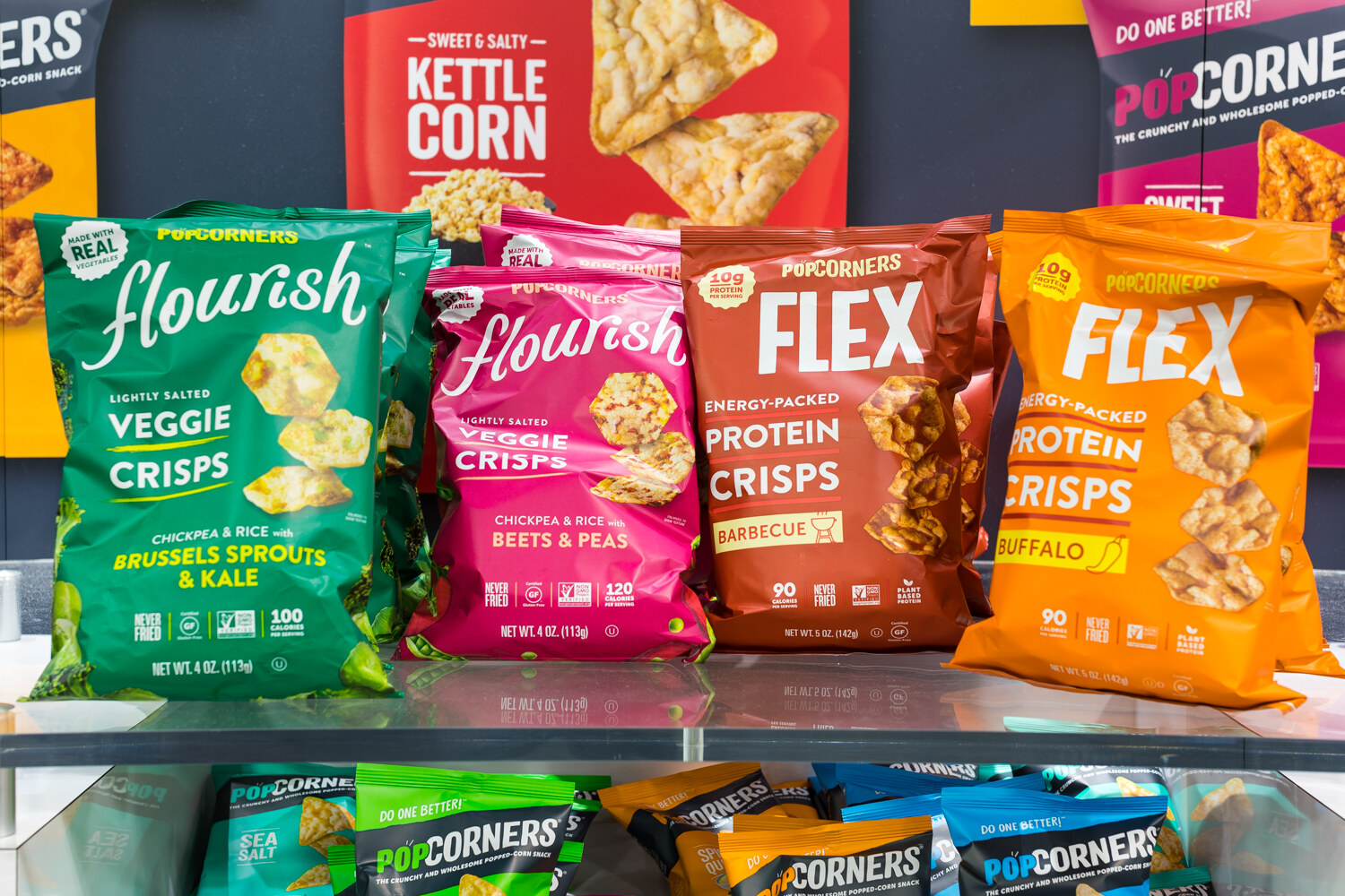 Photo of bags of Flourish veggie crisps and PopCorners snacks on a shelf.
