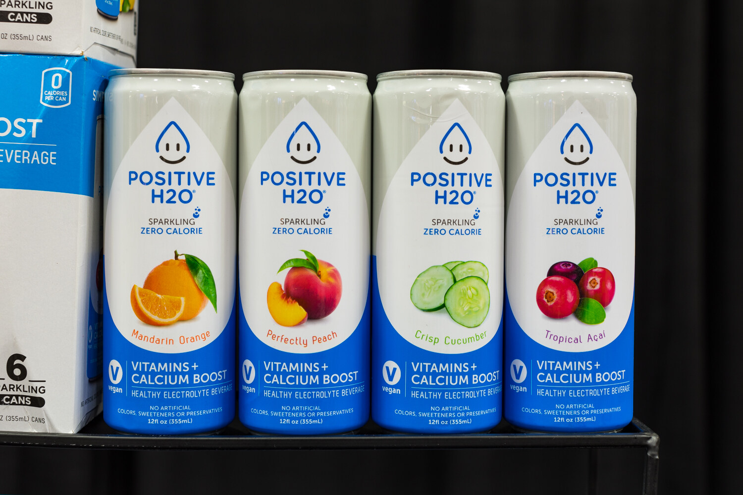 Photo of cans of Positive H2O sparkling water in four flavors.