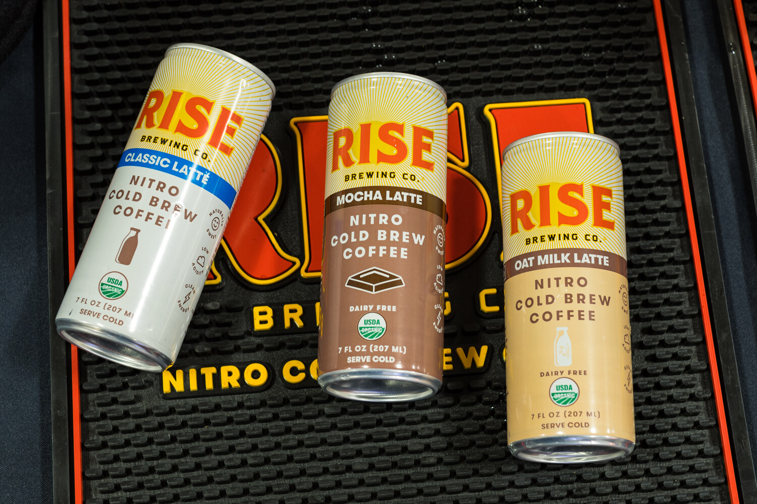 Photo of Rise Brewing Co. nitro cold brew cans on a branded mat.