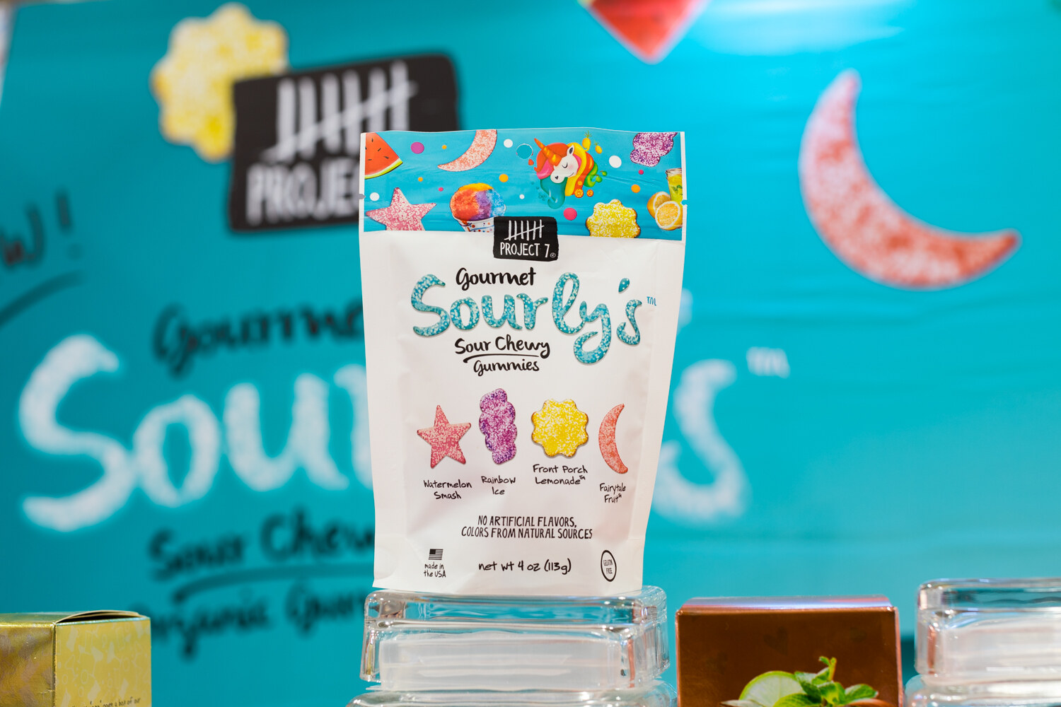 Photo of a bag of Sourly's gourmet sour chewy gummies in front of a teal backdrop.