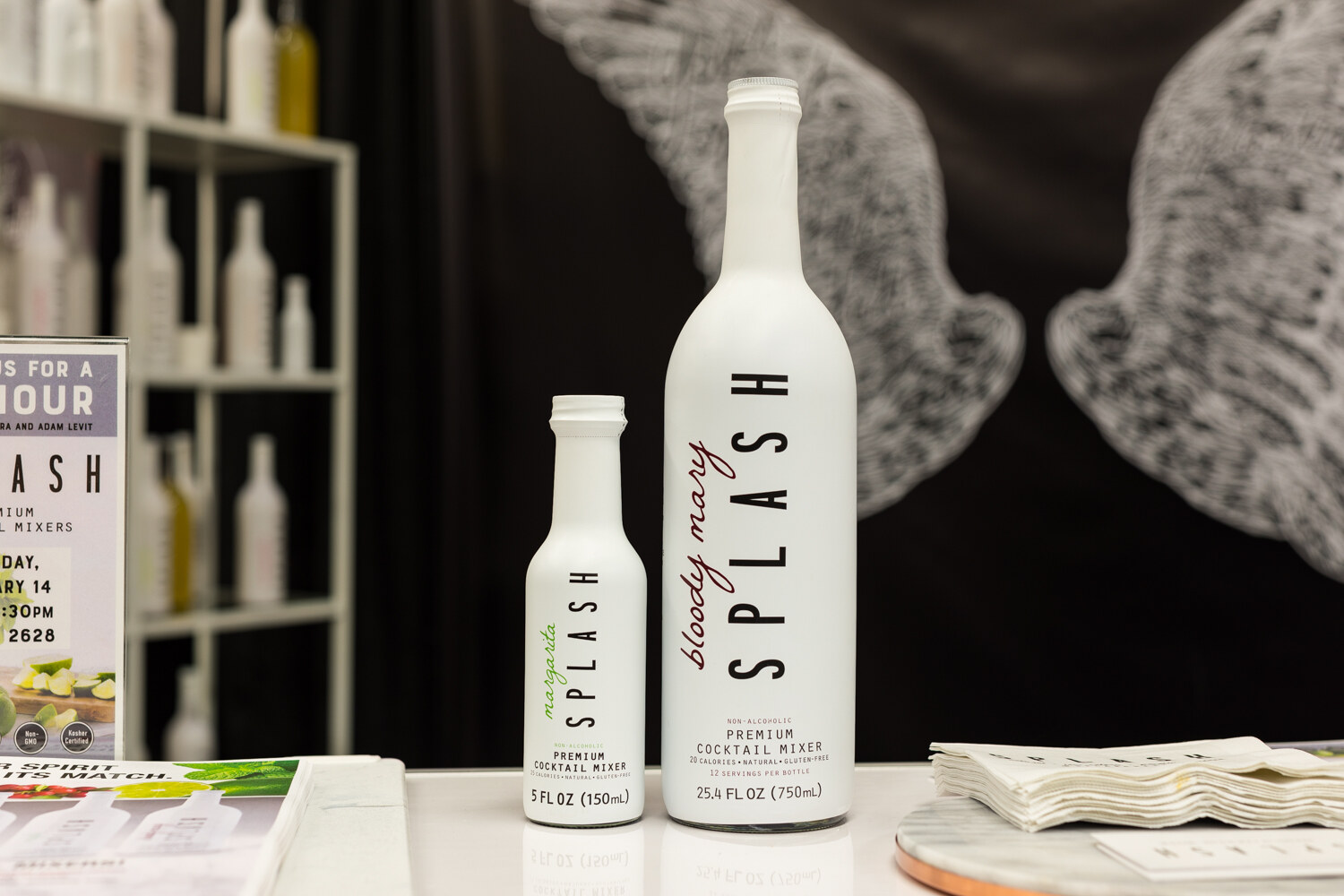 Photo of tall white bottles of Splash premium bloody mary mixer on a counter.