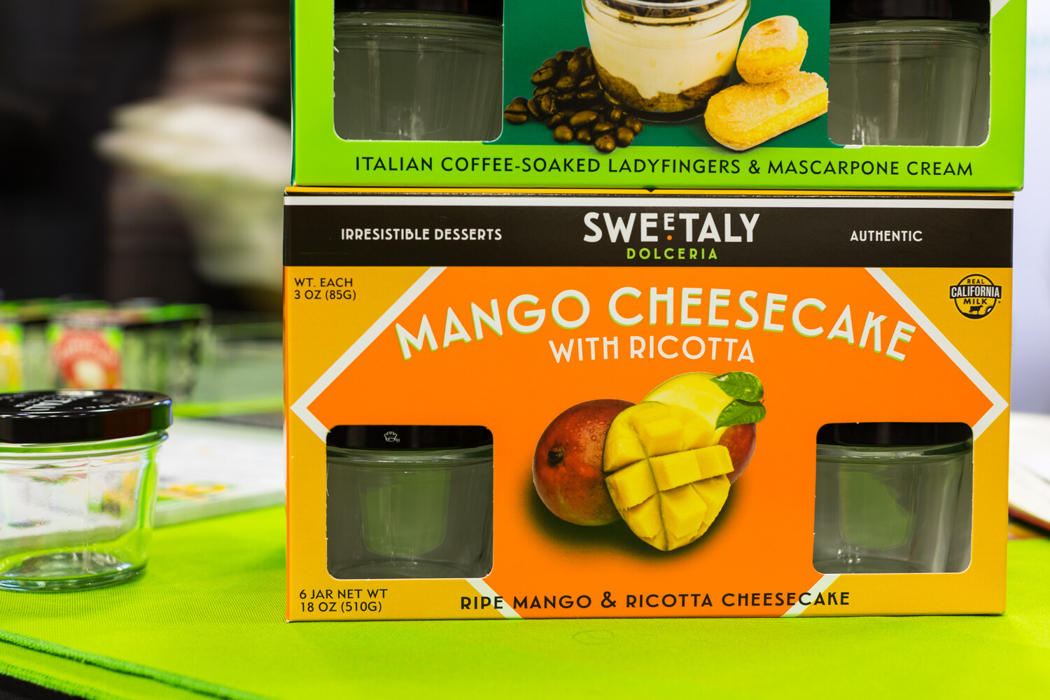 Photo of a Sweetaly mango cheesecake with ricotta dessert box on a green table.