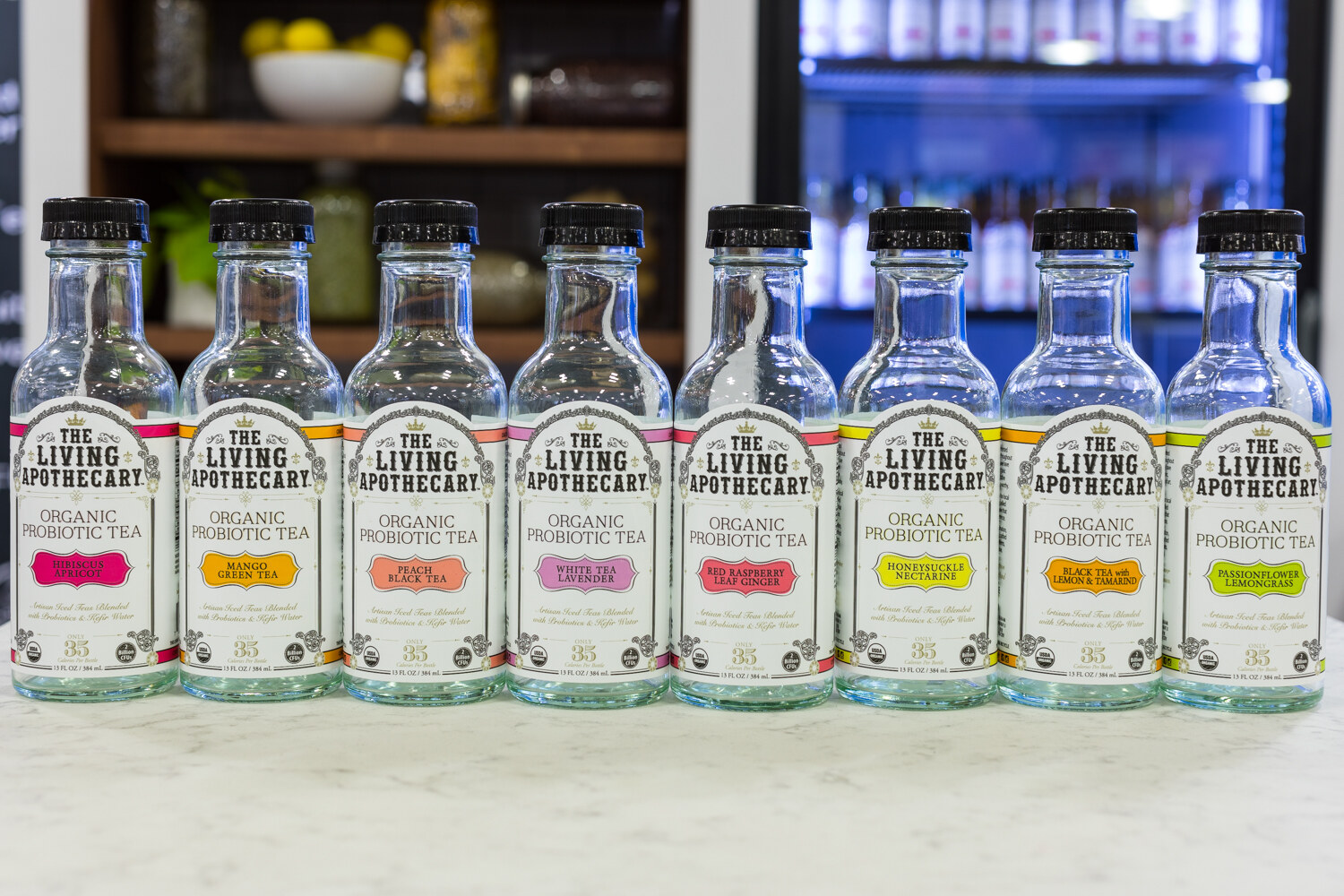 Photo of a line of The Living Apothecary organic probiotic tea bottles.