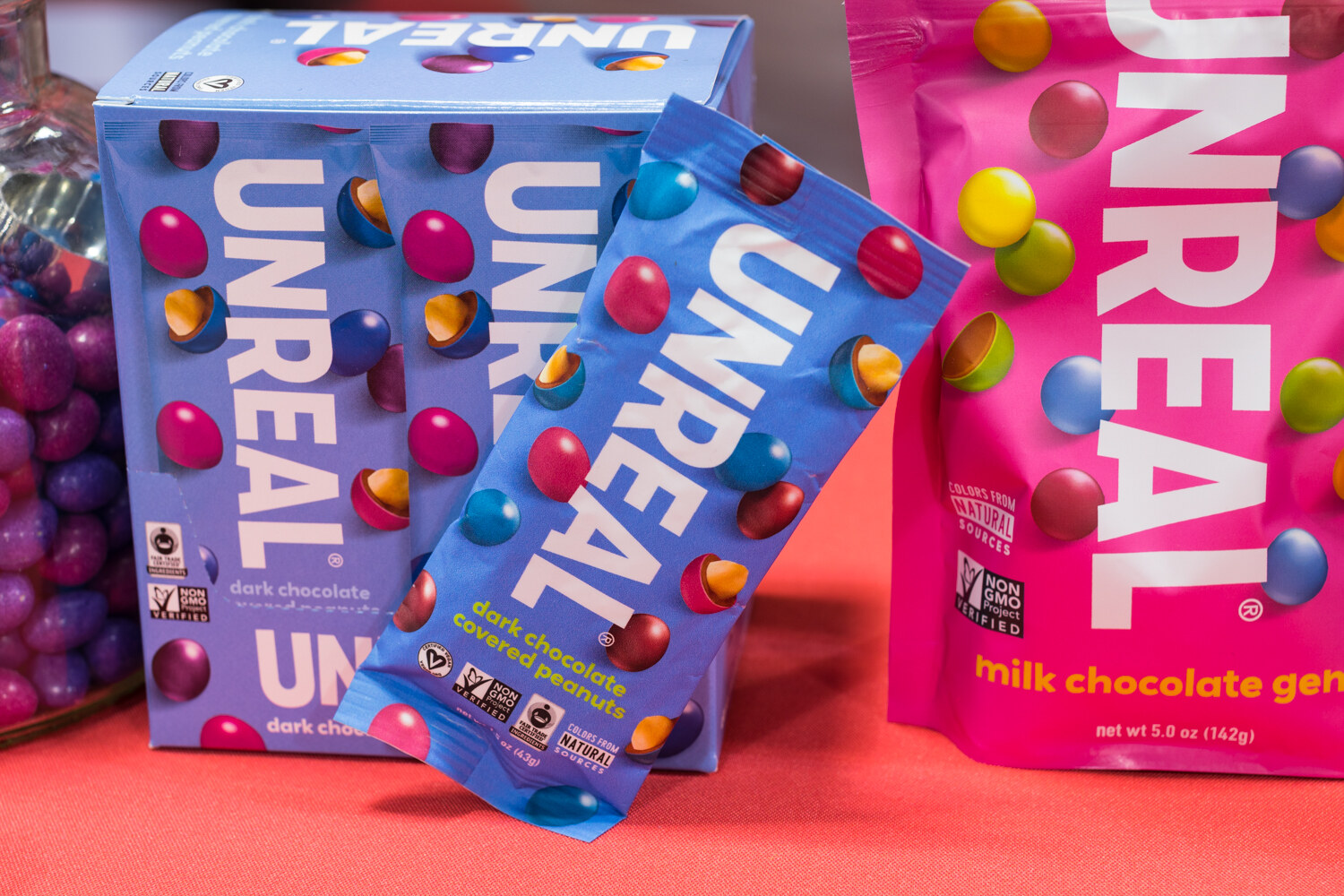 Photo of UNREAL candy boxes and bags on a red tablecloth.