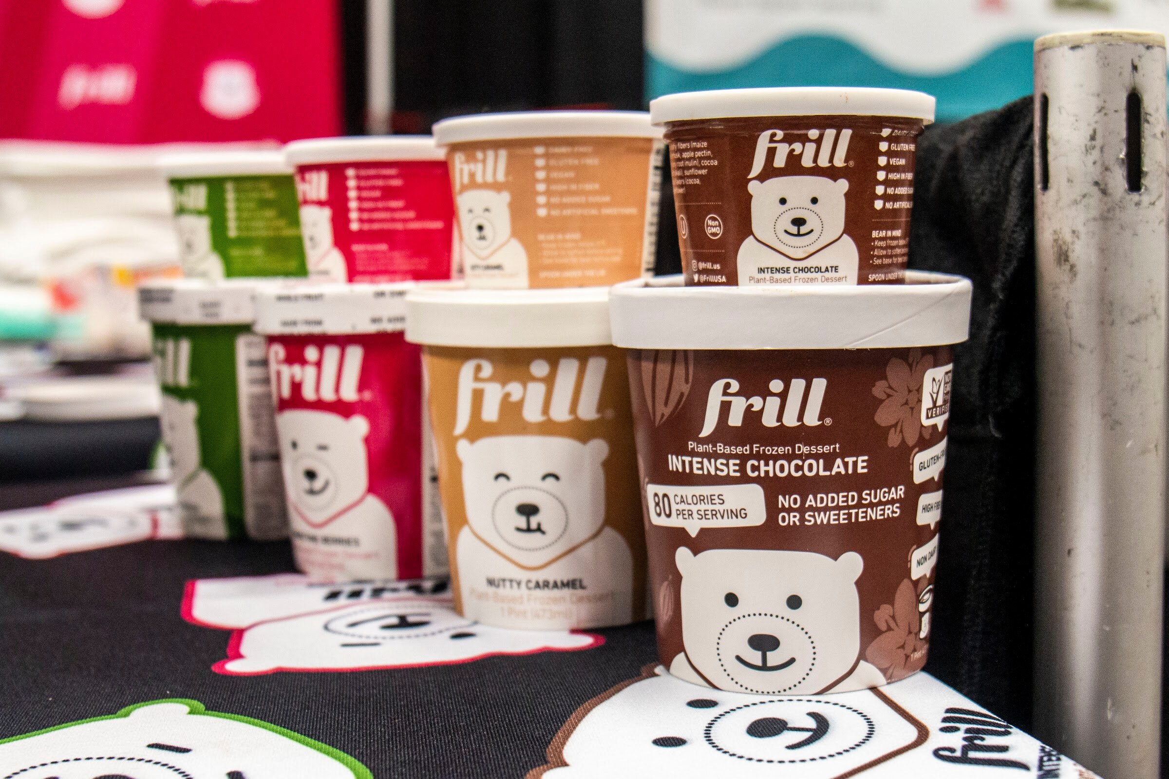 Pints of Frill plant-based frozen dessert in intense chocolate and nutty caramel on a table