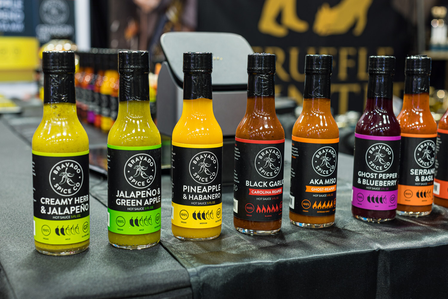 Seven Bravado Spice Co. hot sauce bottles in flavors including creamy herb and jalapeno, pineapple and habanero, and black garlic Carolina Reaper