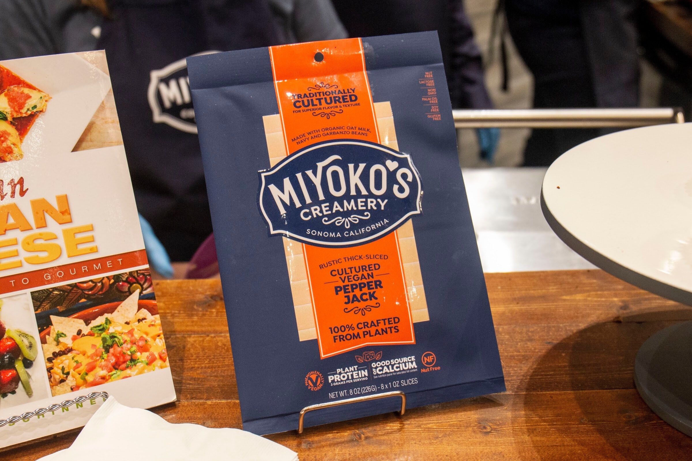 A navy and orange Miyoko's Creamery pepper jack slices package on a stand