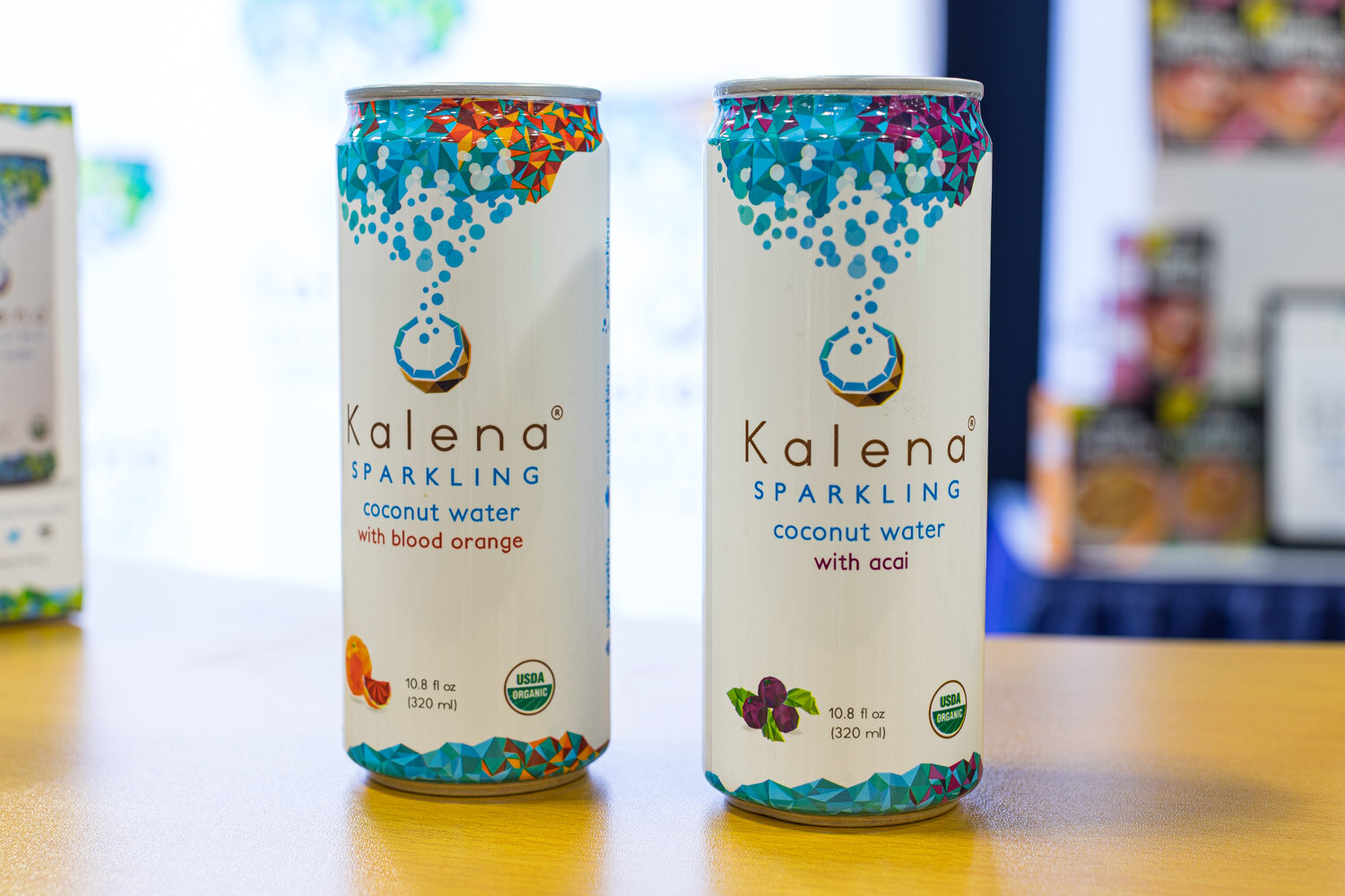 Two Kalena Sparkling coconut water cans with blood orange and acai labels