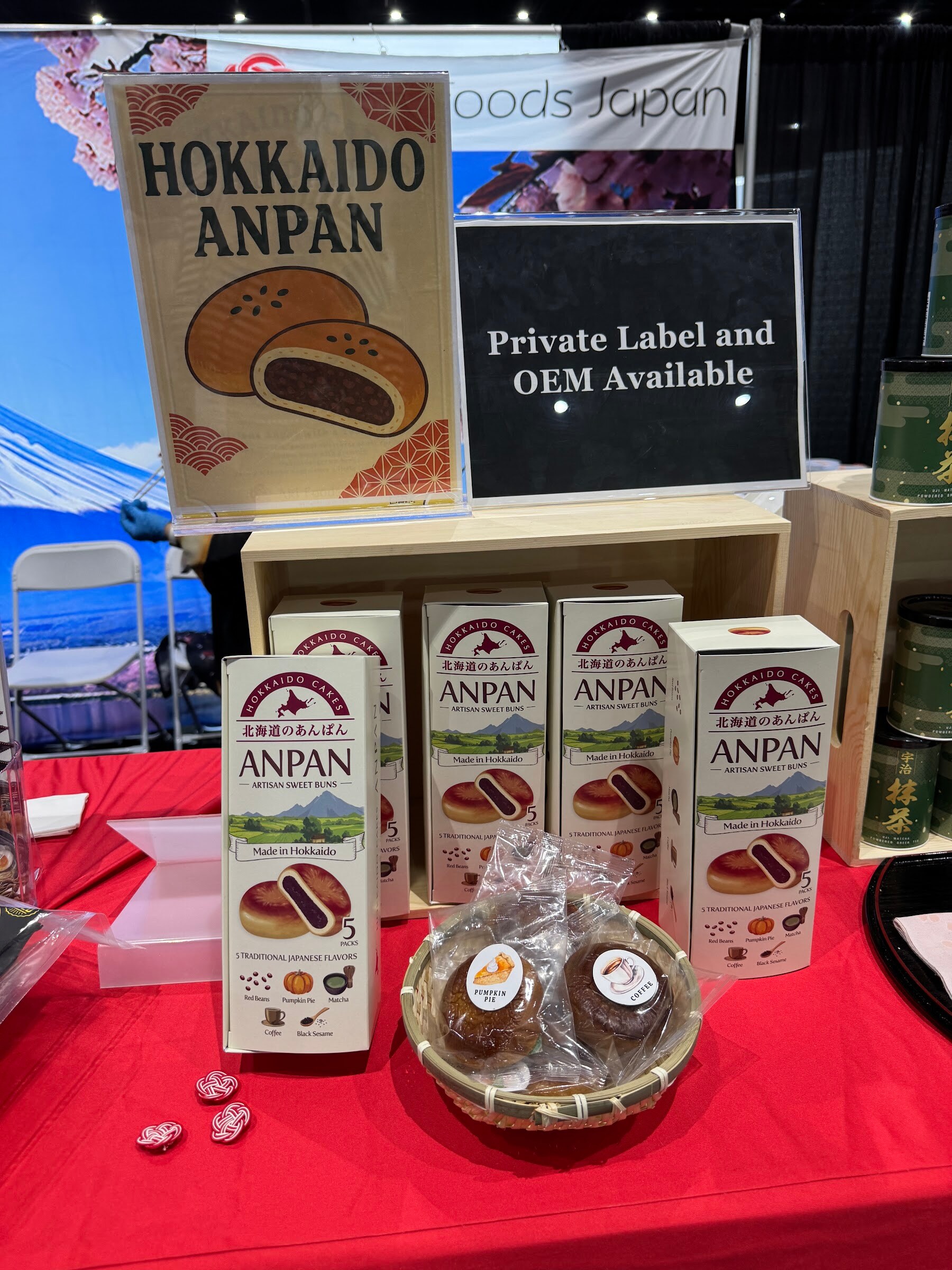 Boxes and a basket of Hokkaido Anpan buns on a red tablecloth with a Private Label and OEM Available sign.