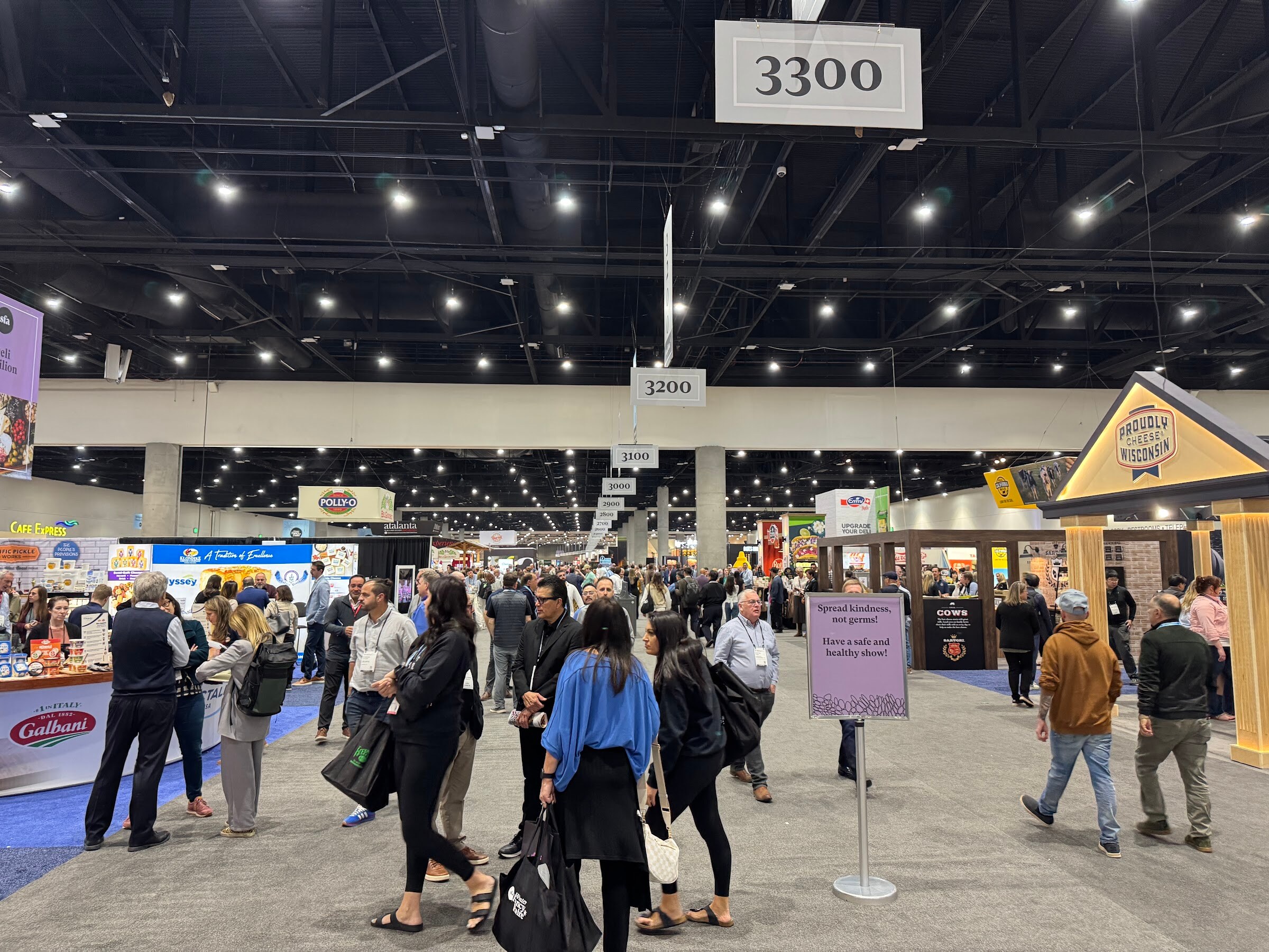 Wide trade show aisle marked 3300 with attendees walking between booths.