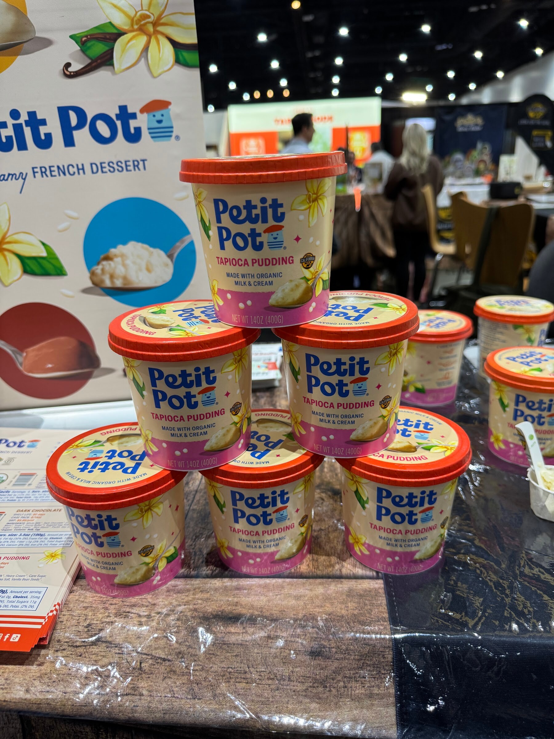 Pyramid of Petit Pot tapioca pudding cups on a wooden table.