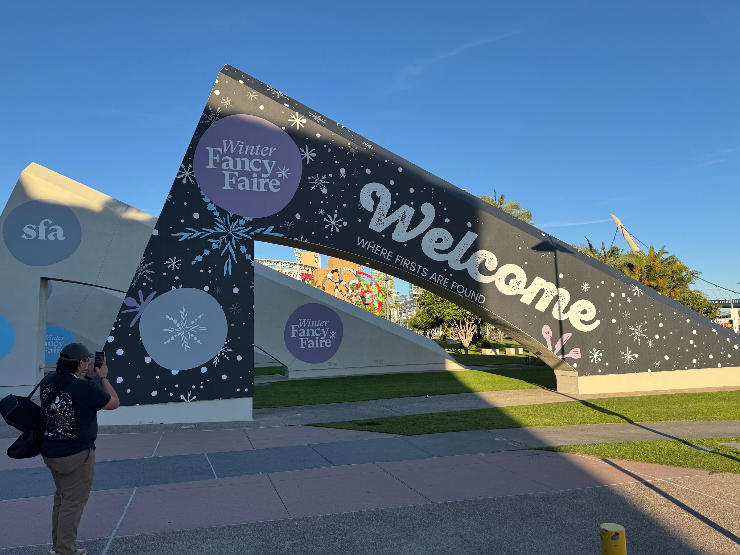 Large dark arch reading Welcome, where firsts are found, with Winter FancyFaire and SFA logos under a blue sky.