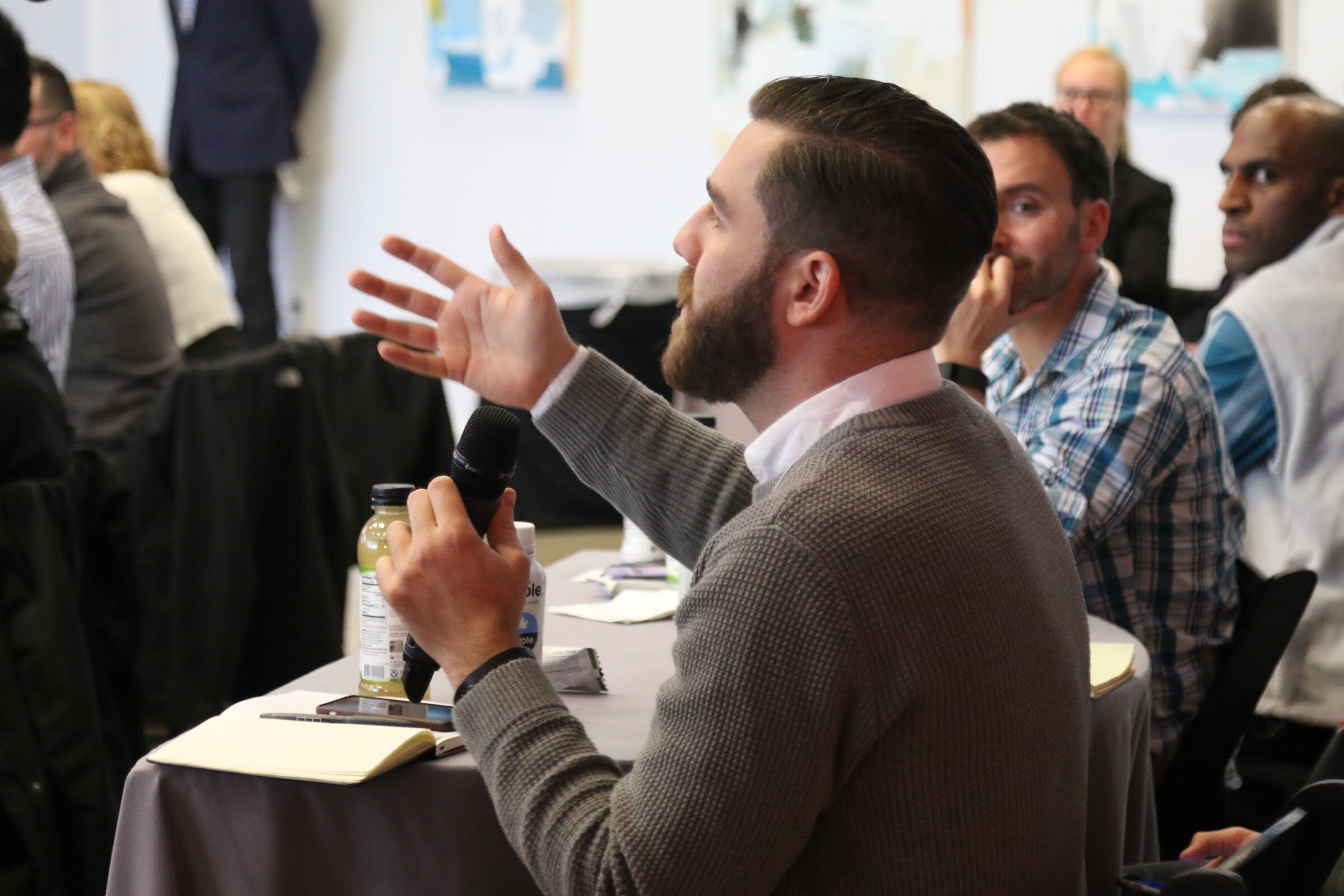 Audience member with microphone gestures asking question.