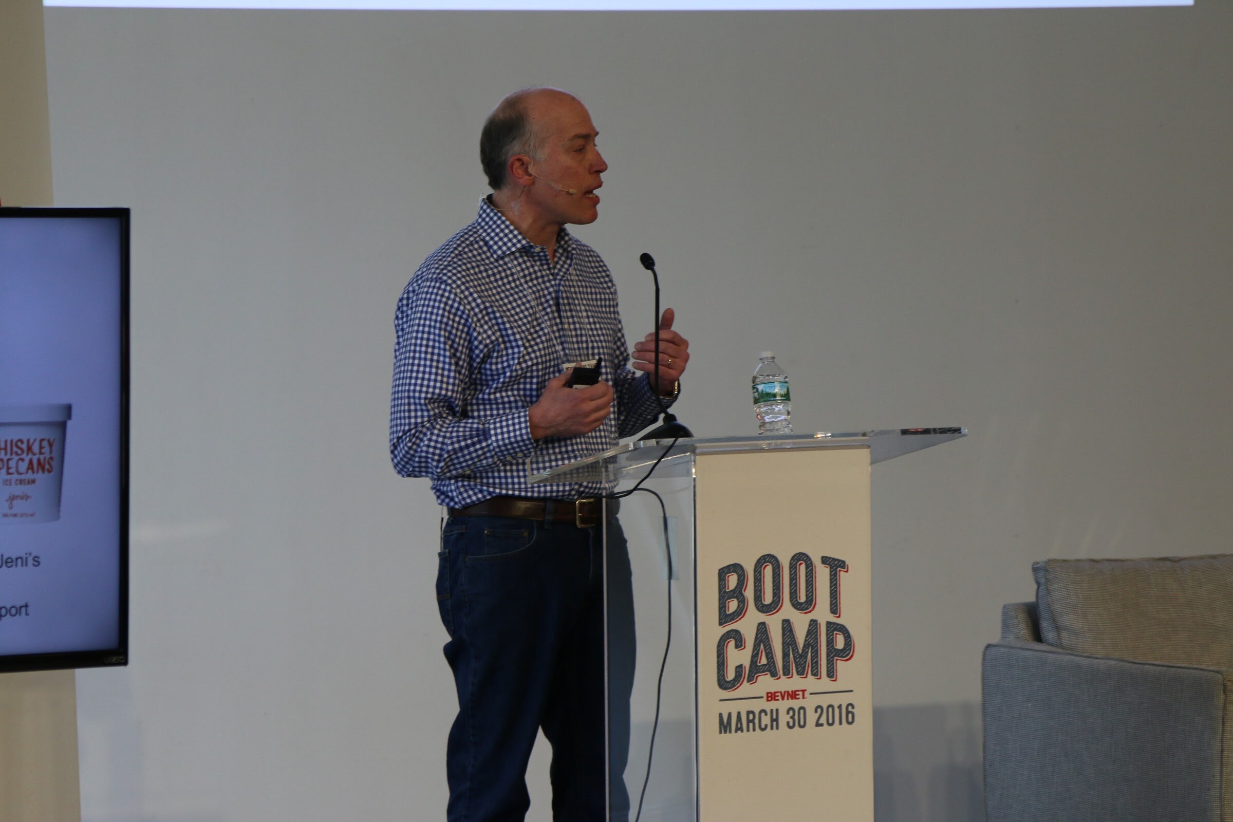 Speaker at Boot Camp podium, clicker in hand, monitor partly shows ice cream pint slide.