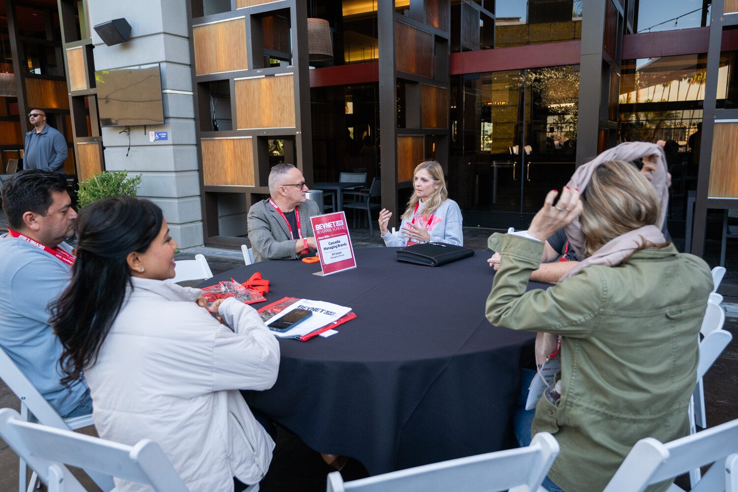 Attendees sit around a round table with a pink table sign.