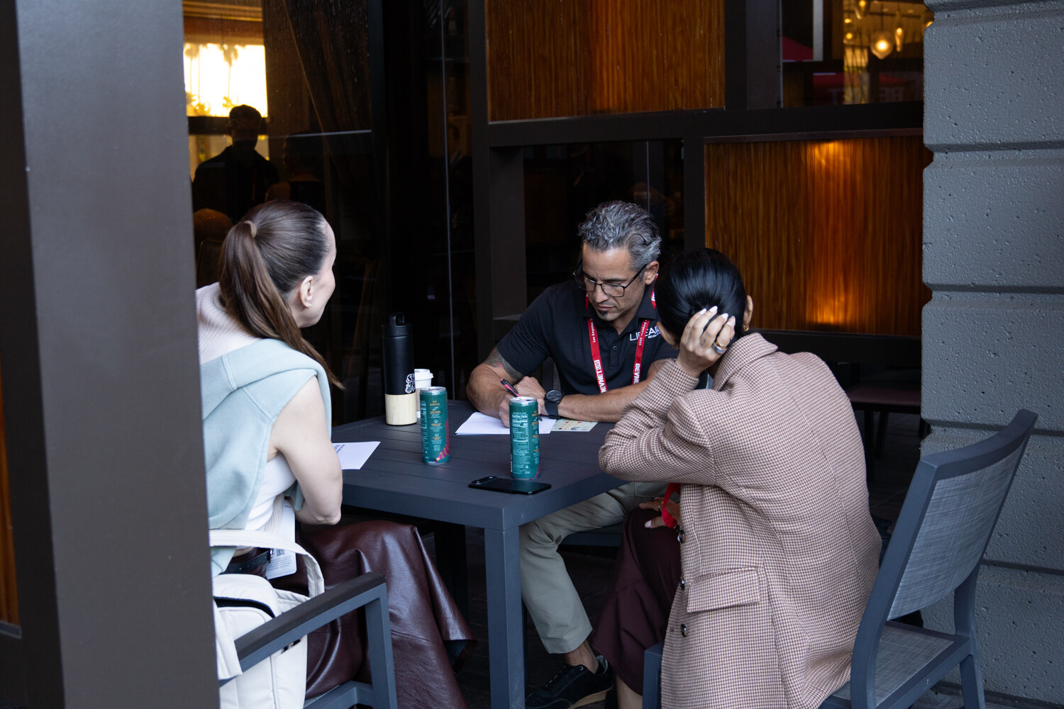 Three people sit at a table with water bottles.
