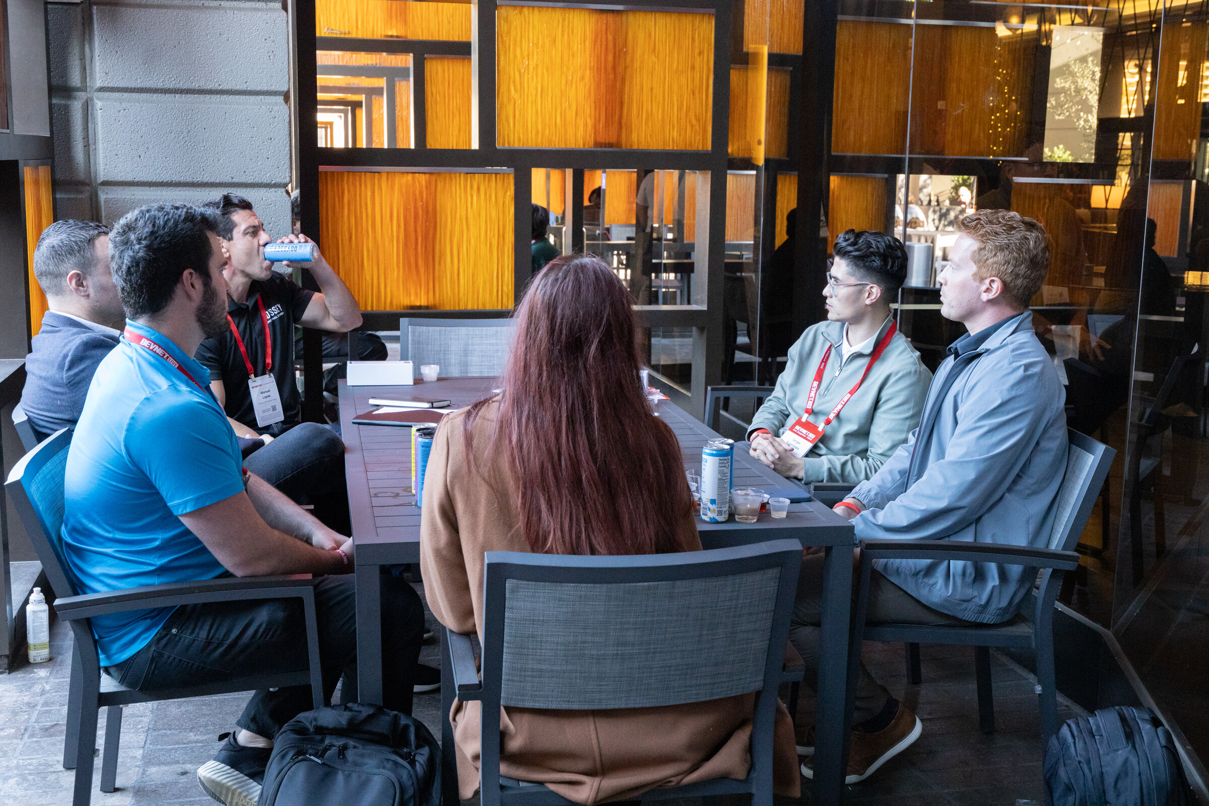 A group of attendees sits around a patio table.