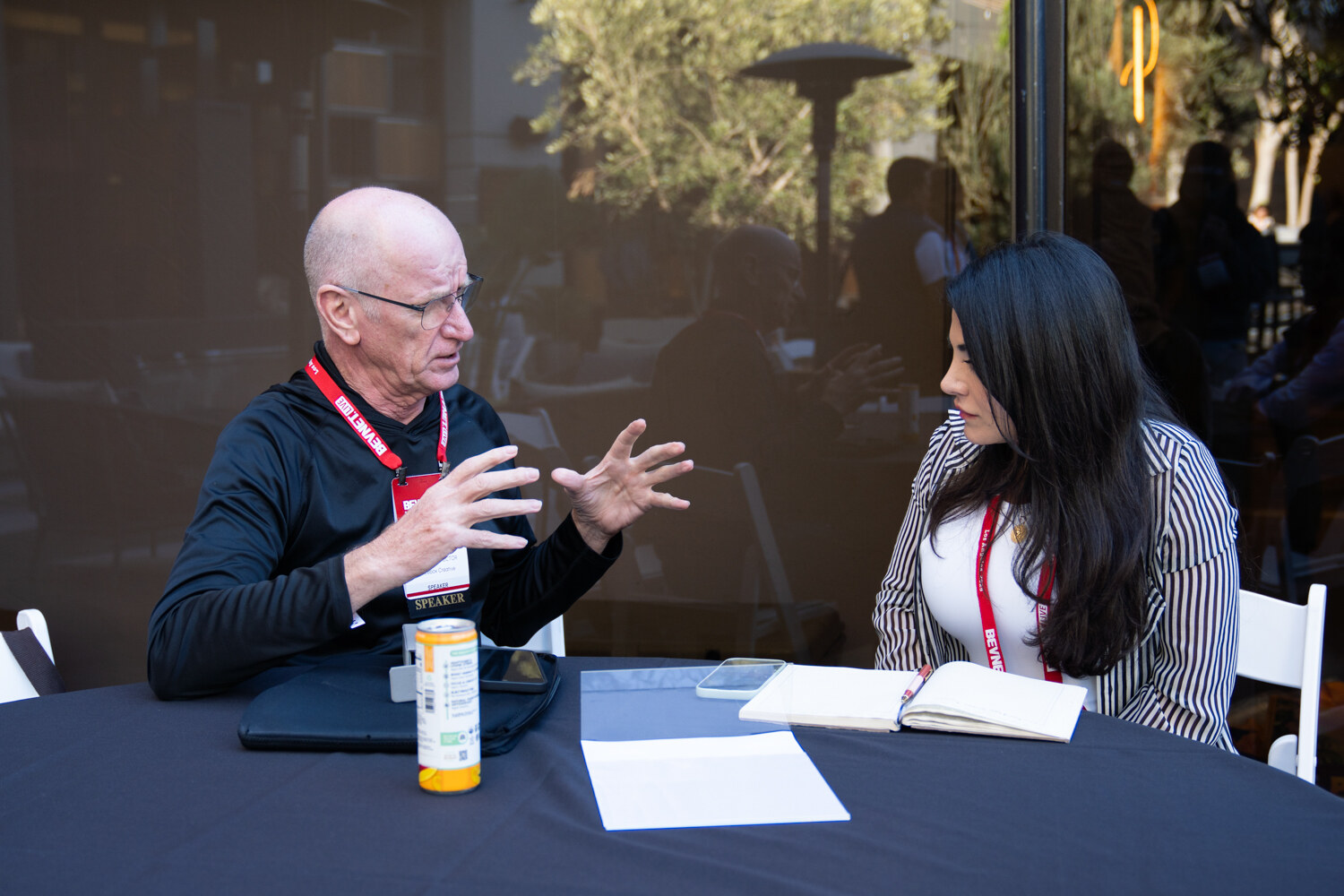 A man holds a product while talking with a woman.