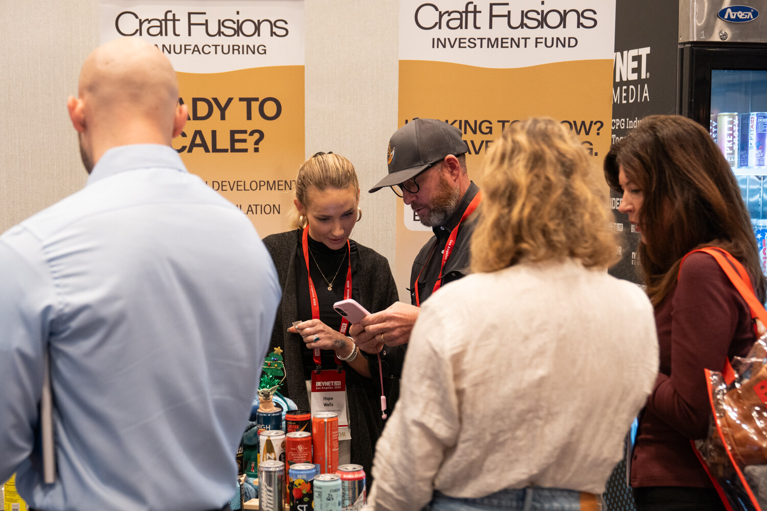 Attendees talk and look at phones in front of Craft Fusions banners.