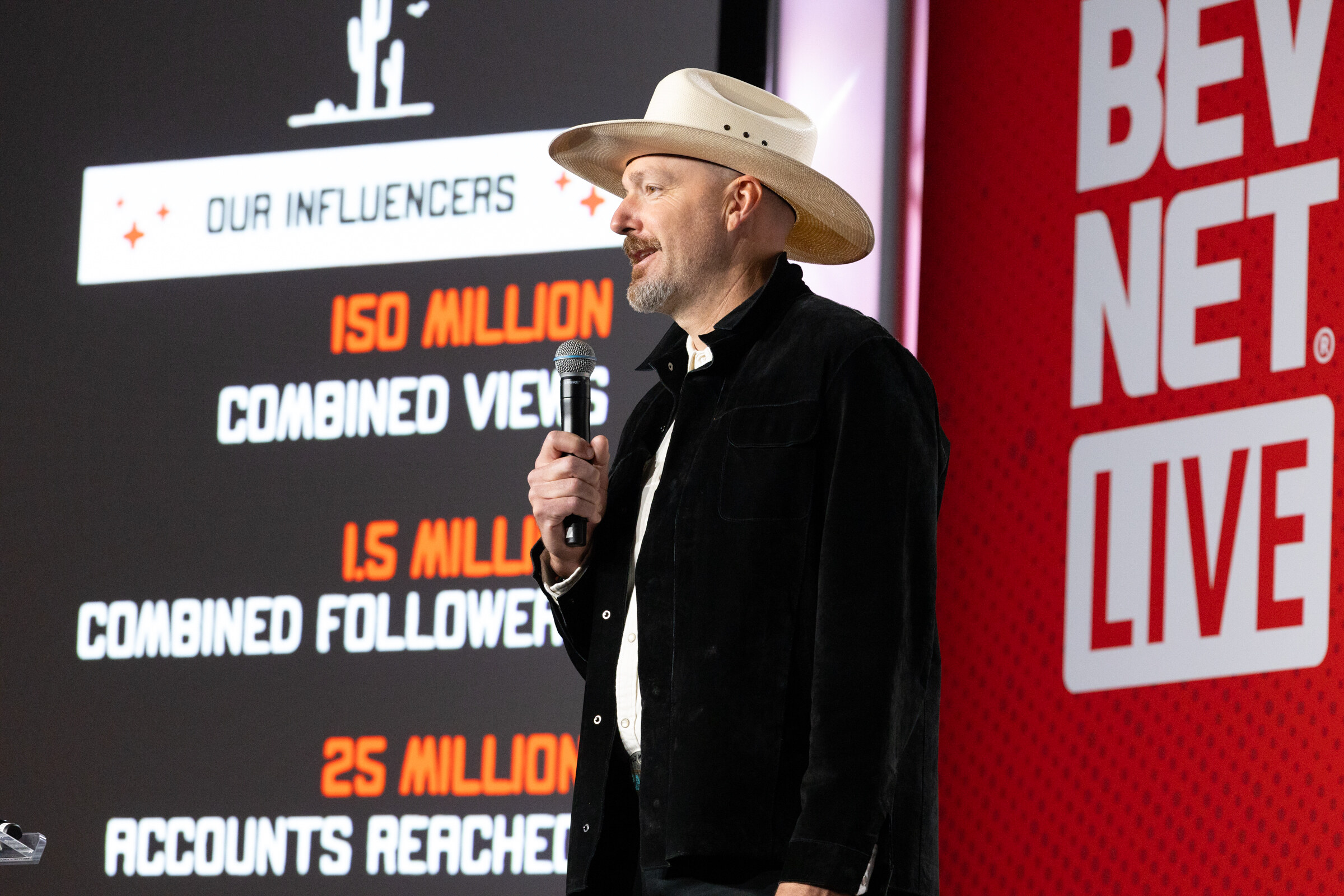 A man in a cowboy hat stands in front of a slide of influencer statistics.