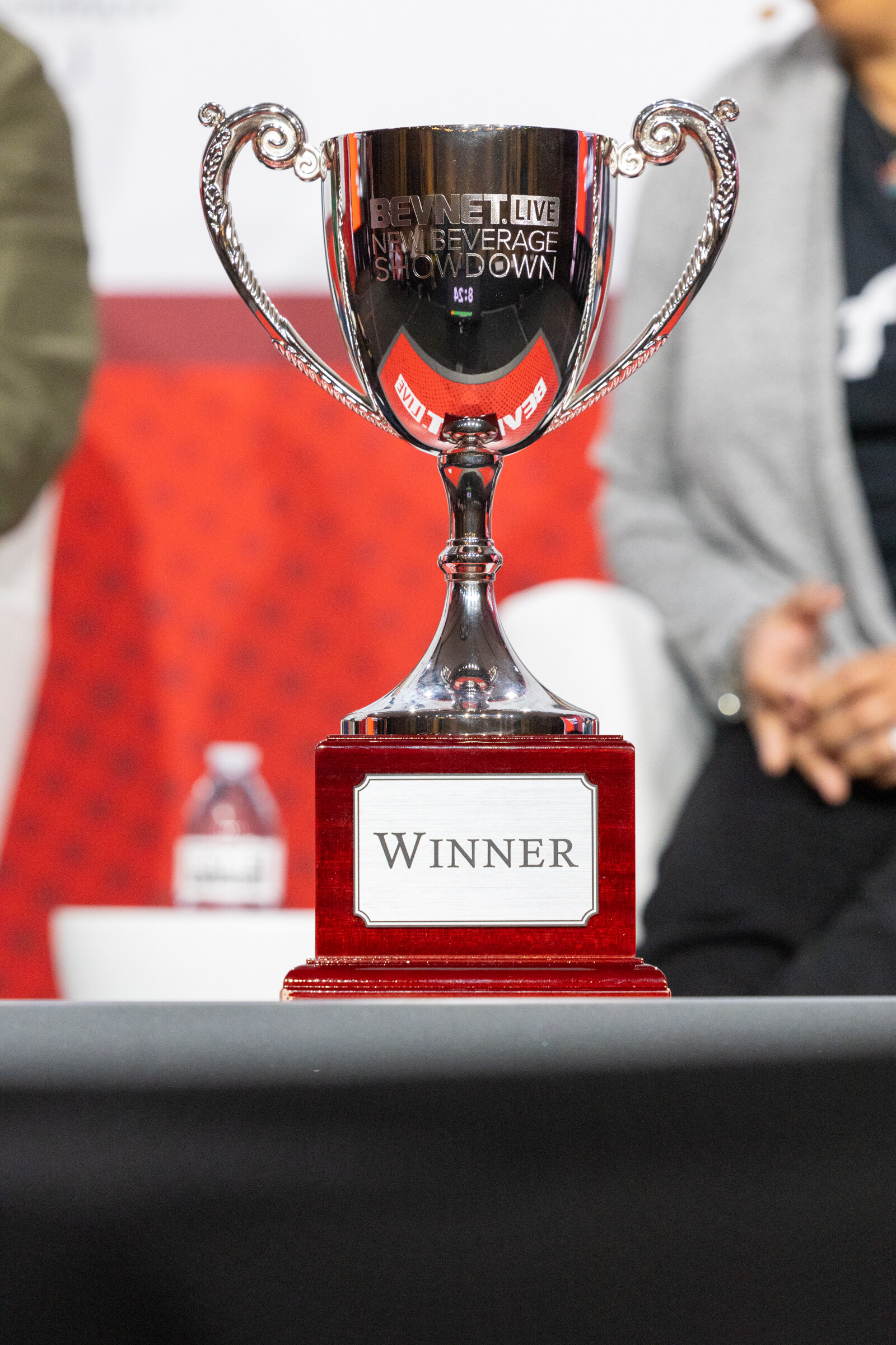 A silver cup labeled Winner stands on a table.