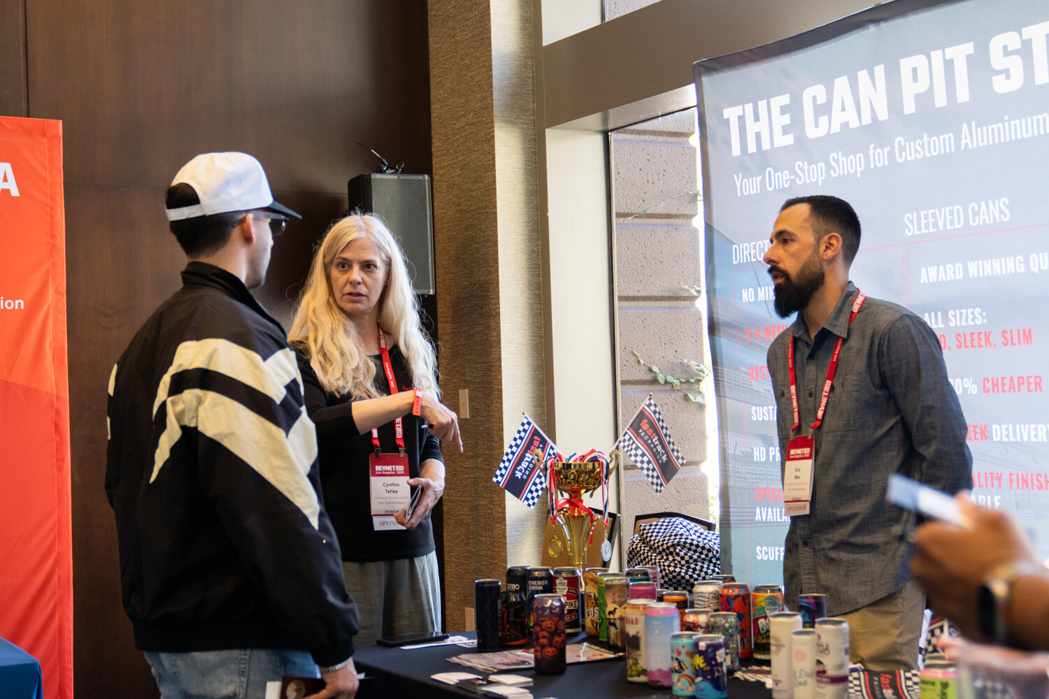 Attendees talk at a booth with a Can Pit Stop banner.