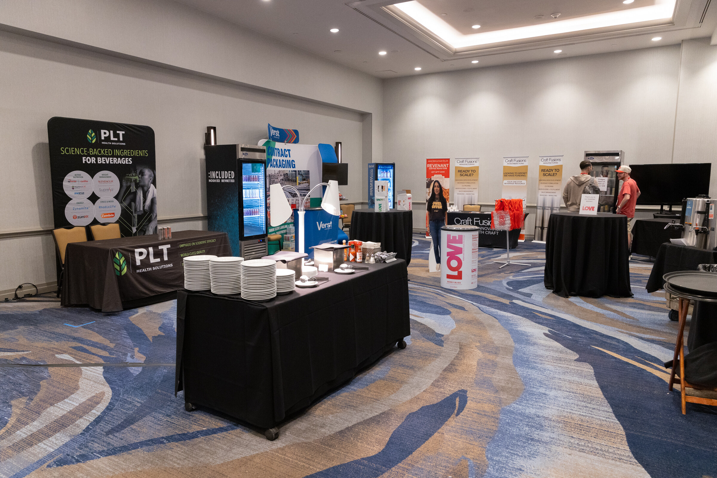 A wide view of booths with PLT, Verst and Craft Fusions tables.