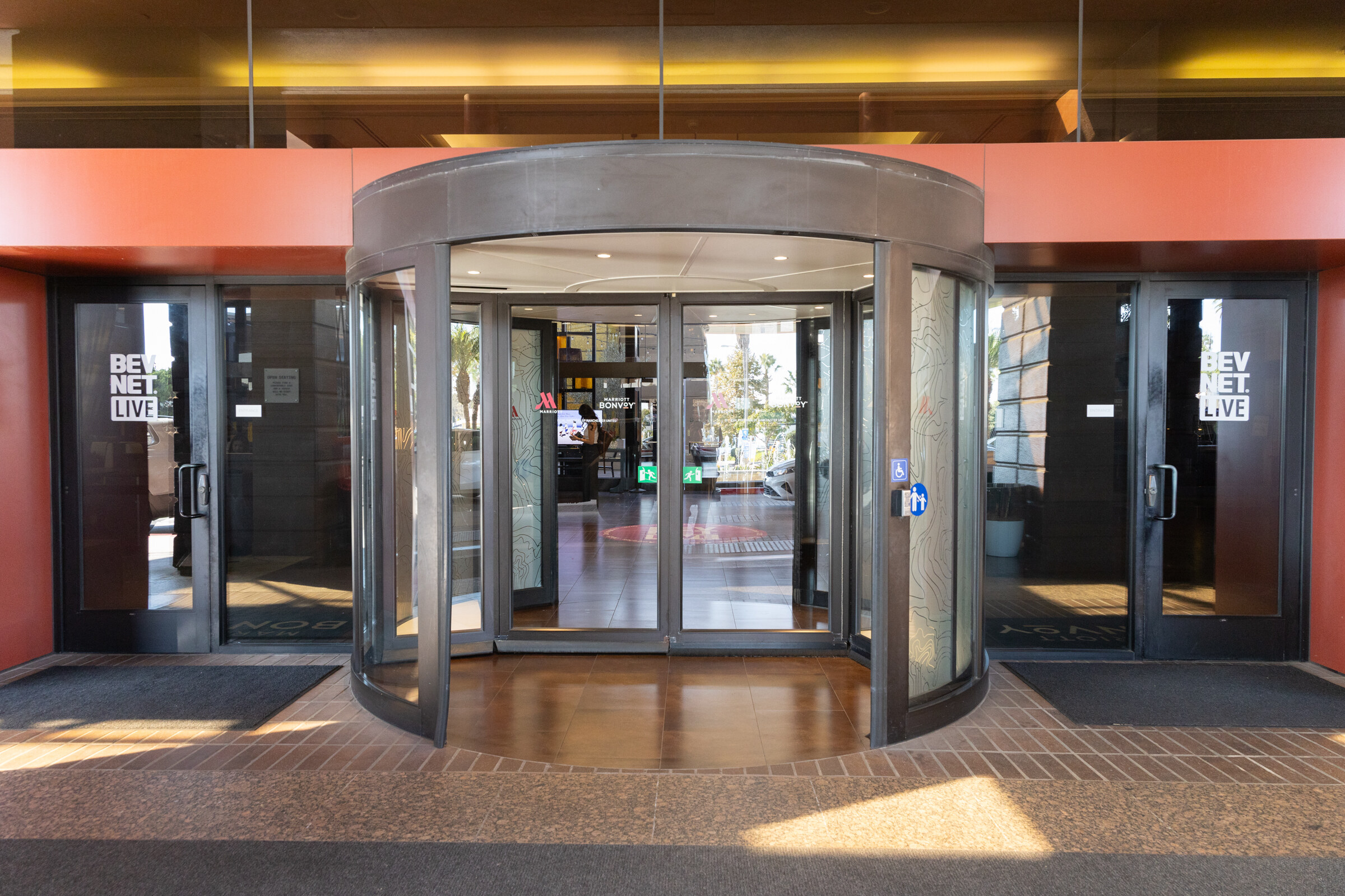 Revolving glass doors with BevNET Live banners at the hotel entrance.