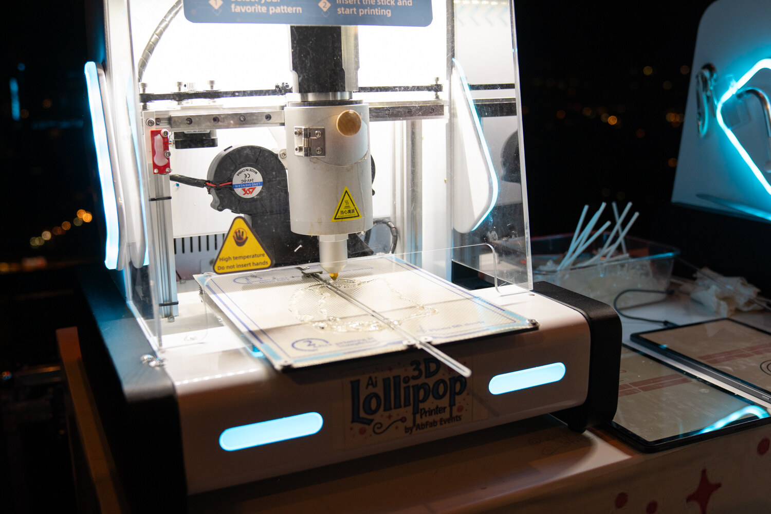 A clear machine with a Lollipop logo works on a table.